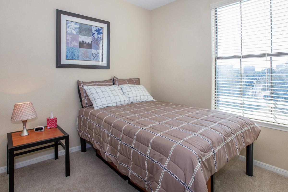 a bedroom with a bed and desk in a room