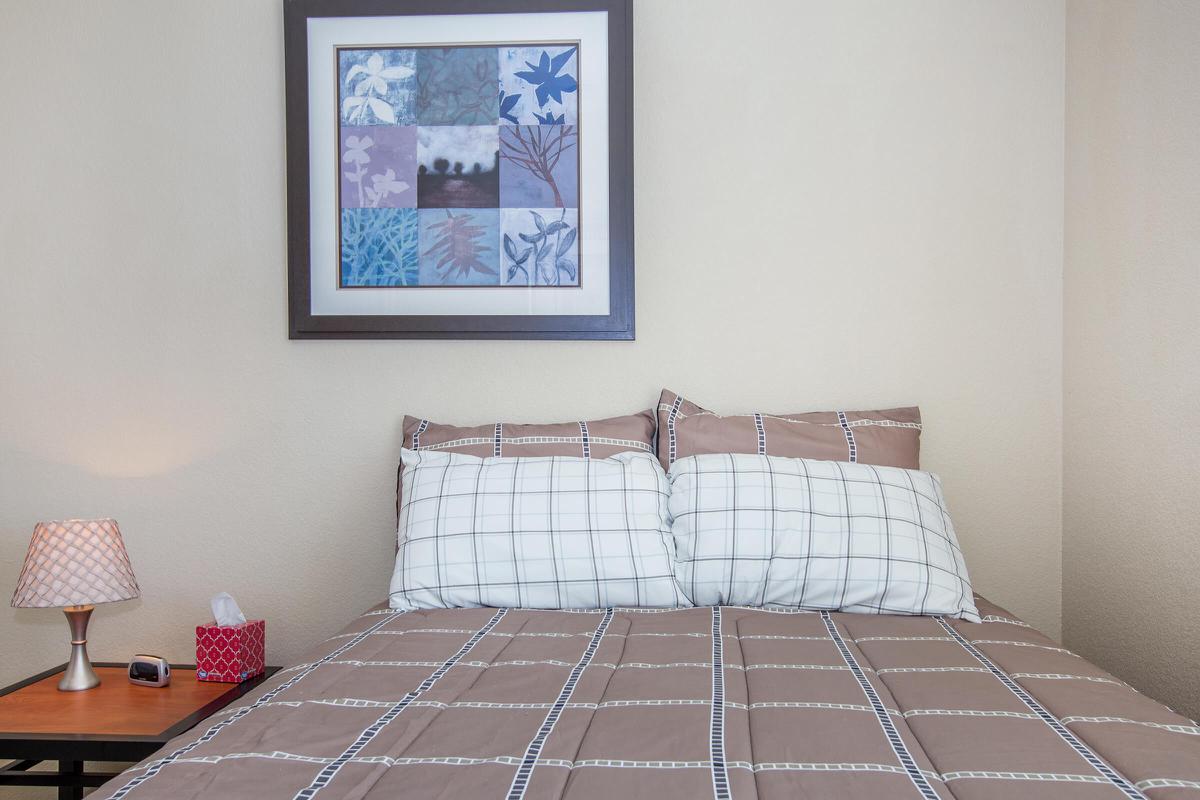 a bedroom with a bed and desk in a room