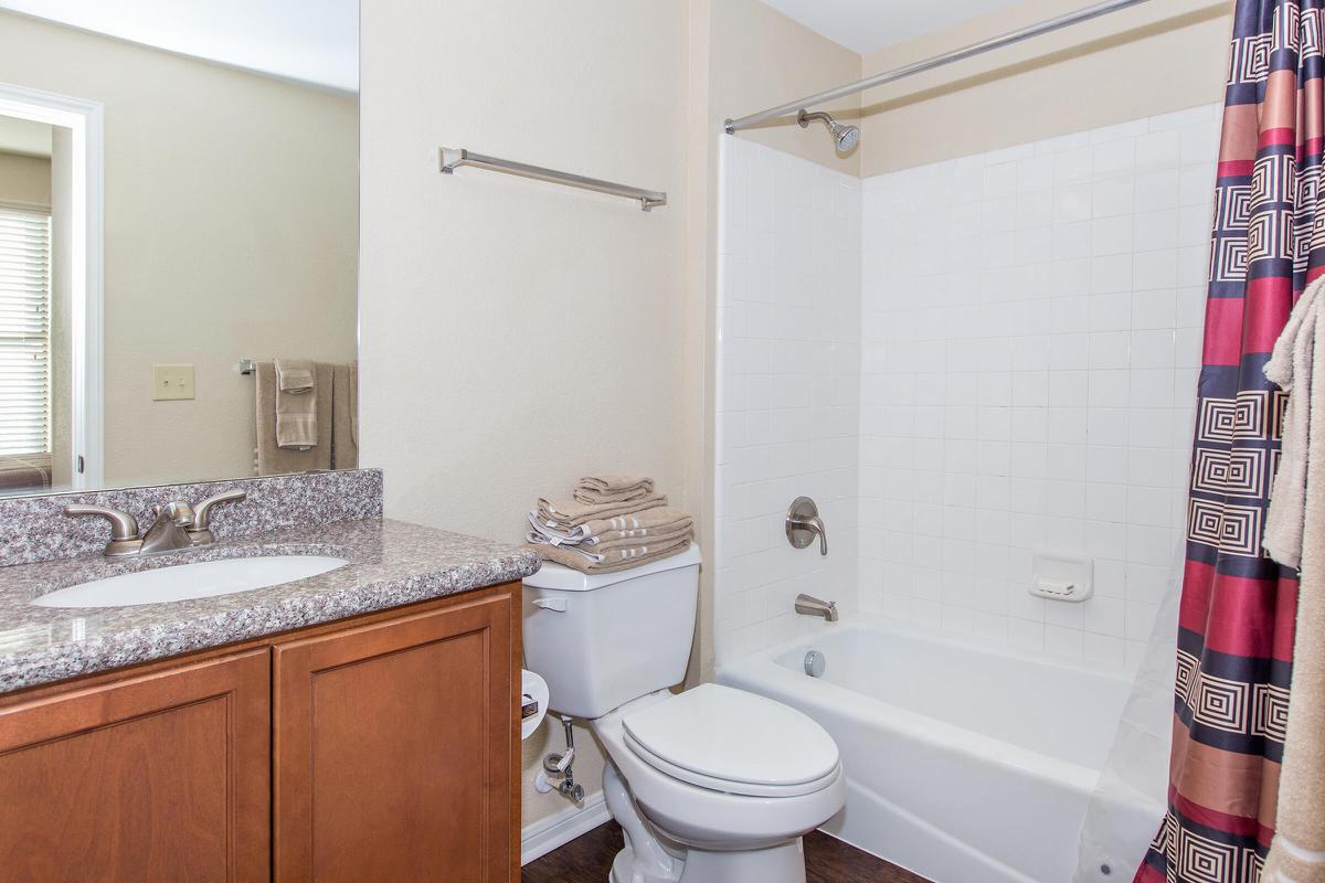 a white sink sitting next to a shower