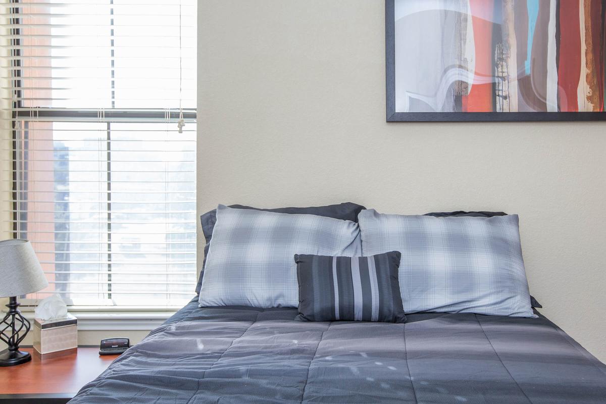 a bedroom with a bed and desk in a room