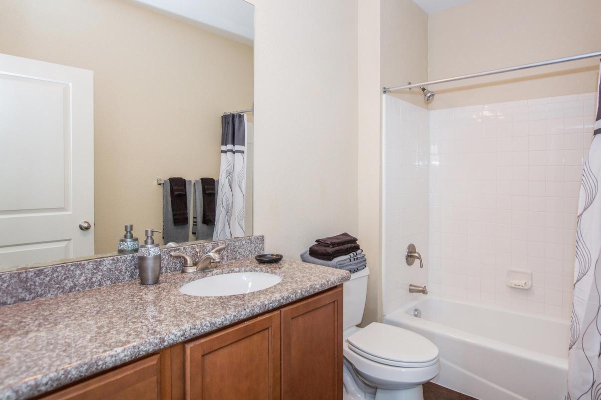 a white sink sitting next to a shower