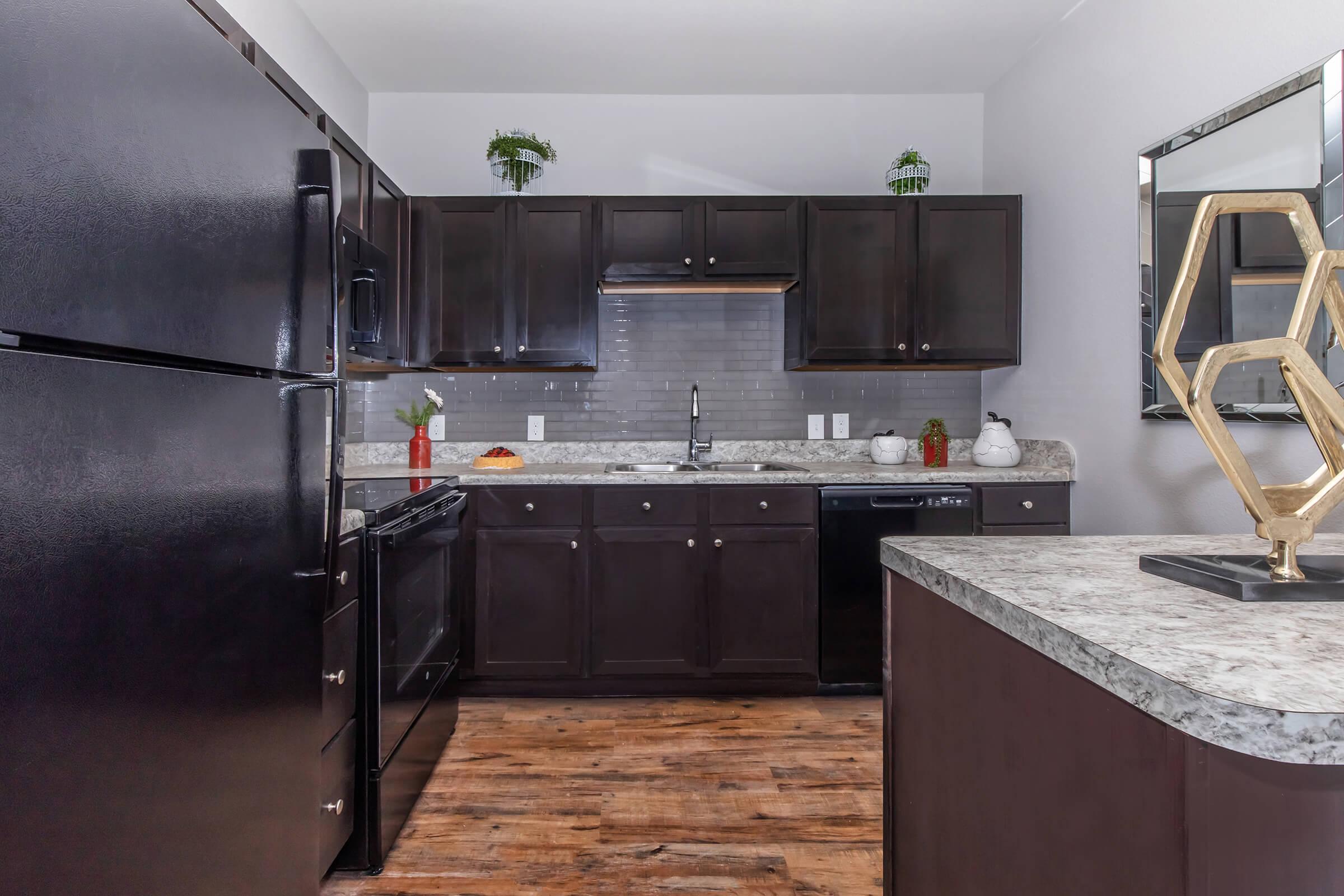 a large kitchen with stainless steel appliances and wooden cabinets