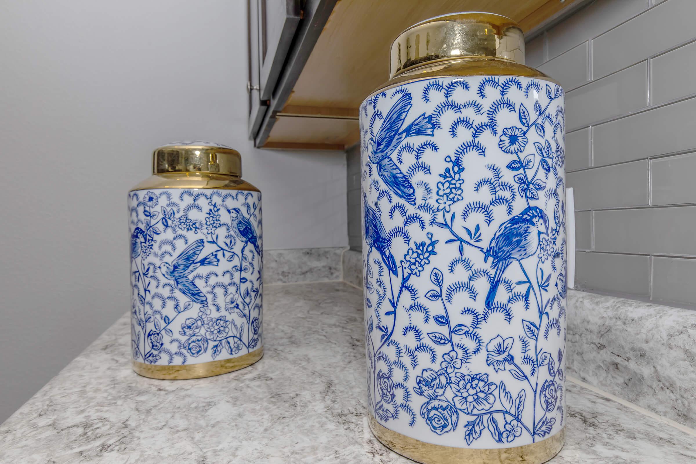 a glass with a blue can next to a vase