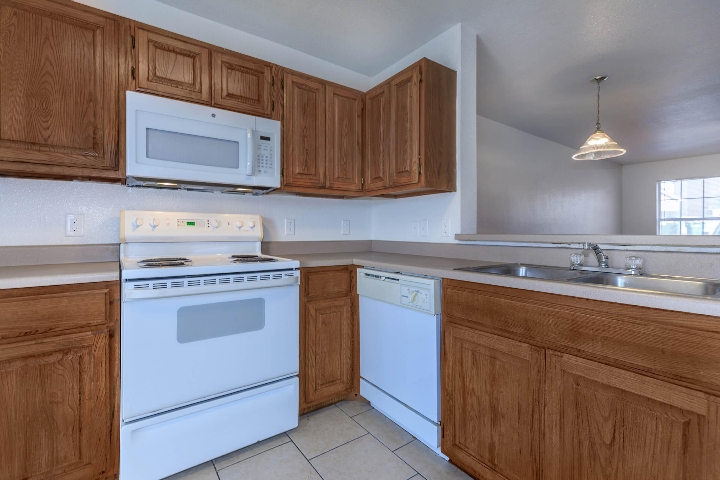 a kitchen with wooden cabinets and a microwave