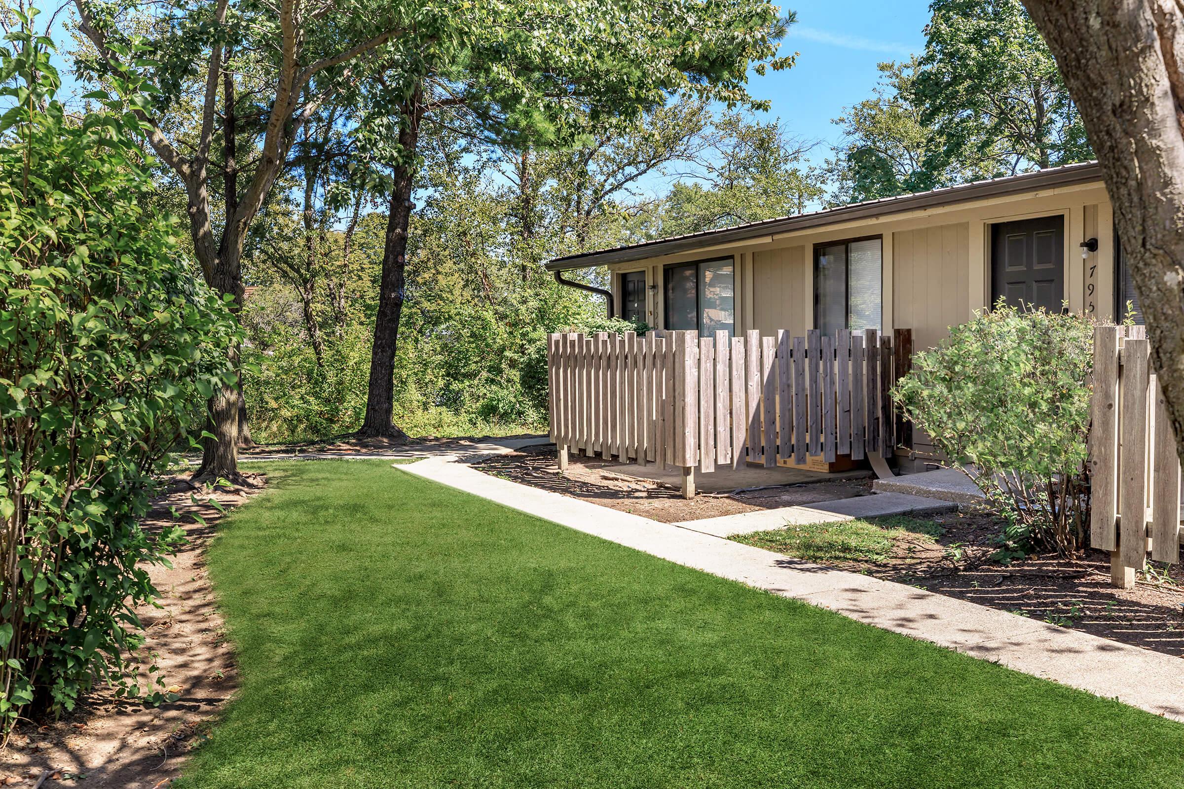 a path with grass in front of a house