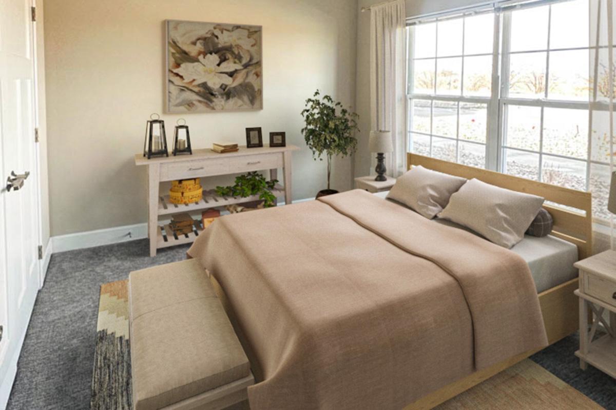 A modern bedroom featuring a large bed with a beige blanket, two side tables with lamps, and a decorative bench at the foot of the bed. The room has a light color palette with a window providing natural light, a potted plant, and a stylish console table with decorative items against one wall.