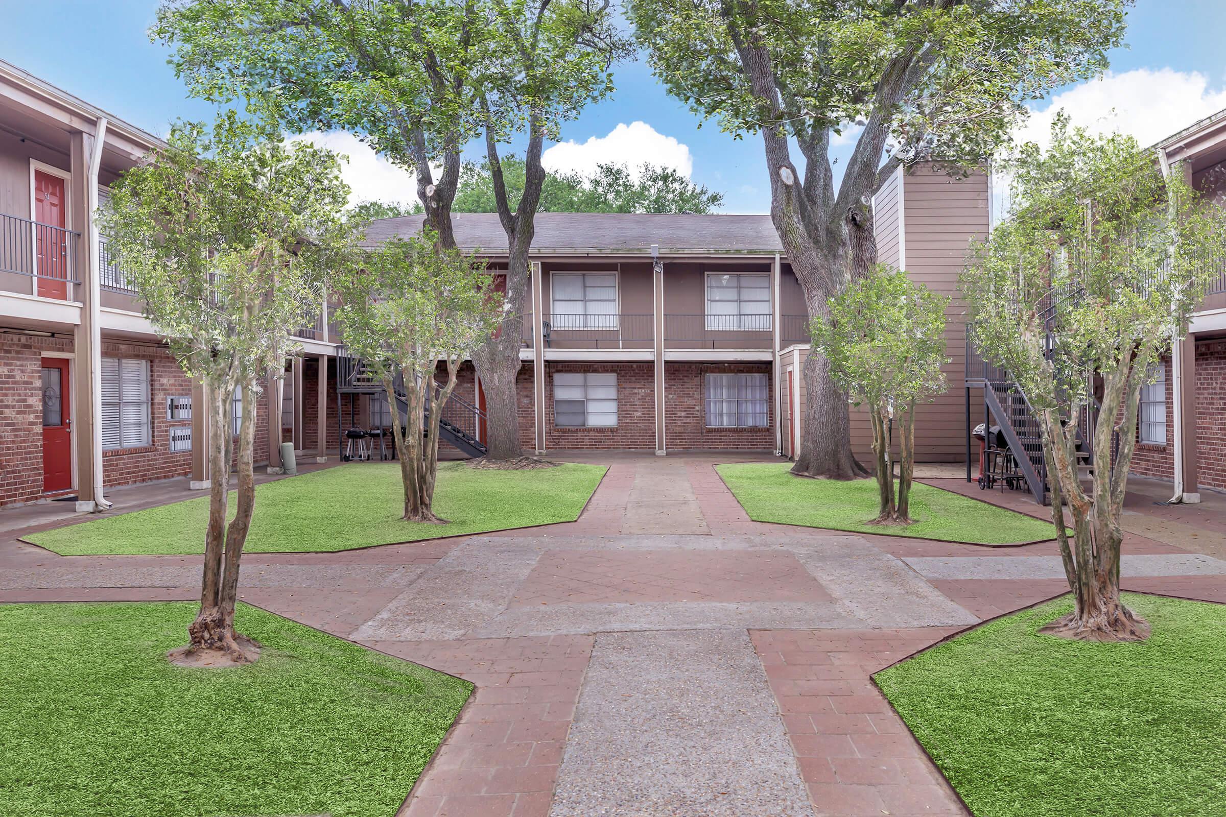 a large lawn in front of a brick building