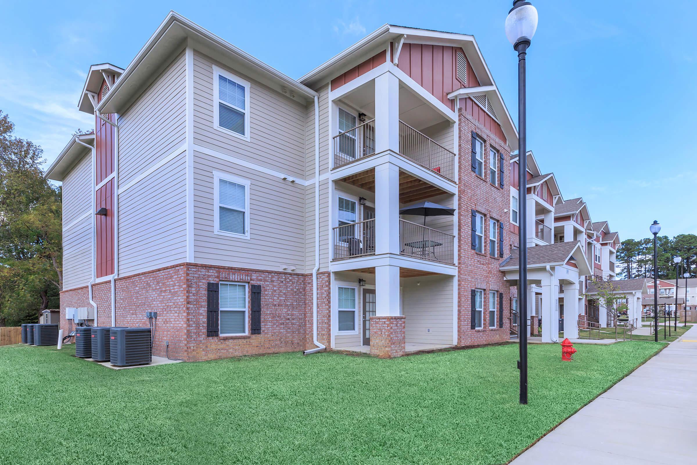 a large lawn in front of a brick building