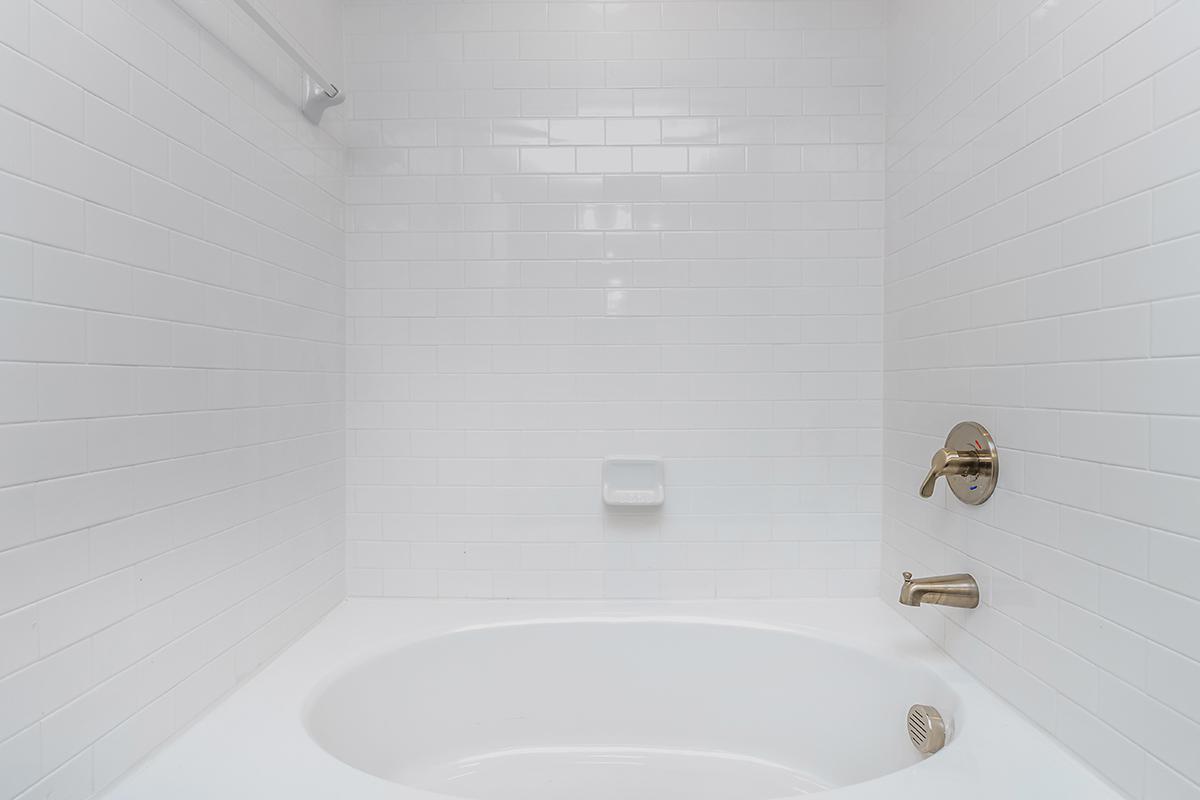 a white tub sitting next to a sink