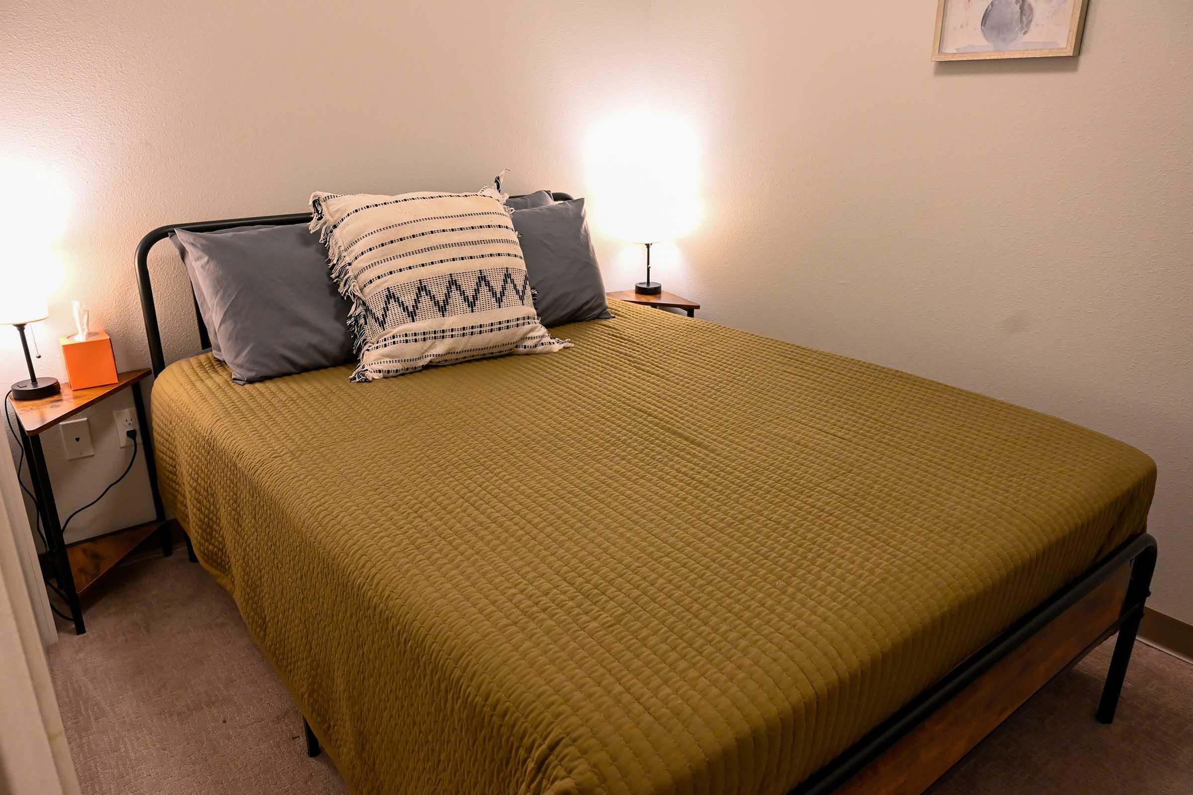 a bedroom with a bed and desk in a hotel room