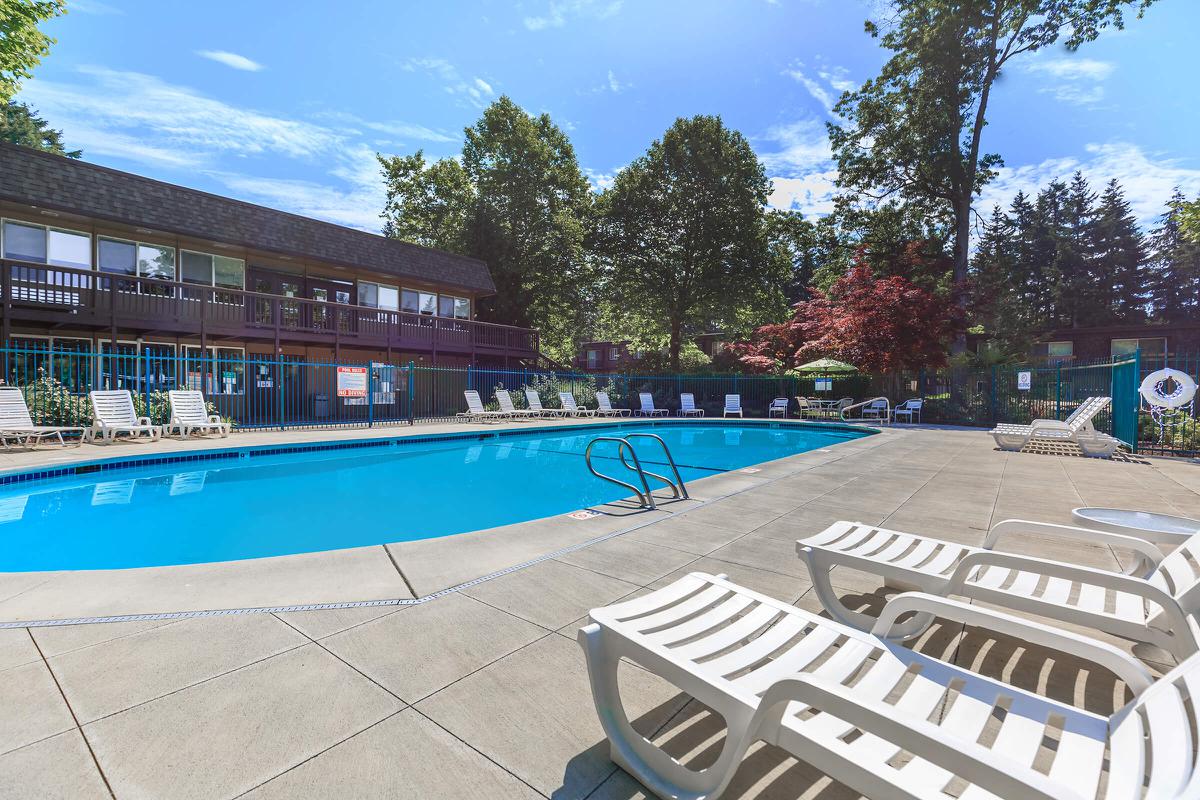 an empty park bench next to a pool