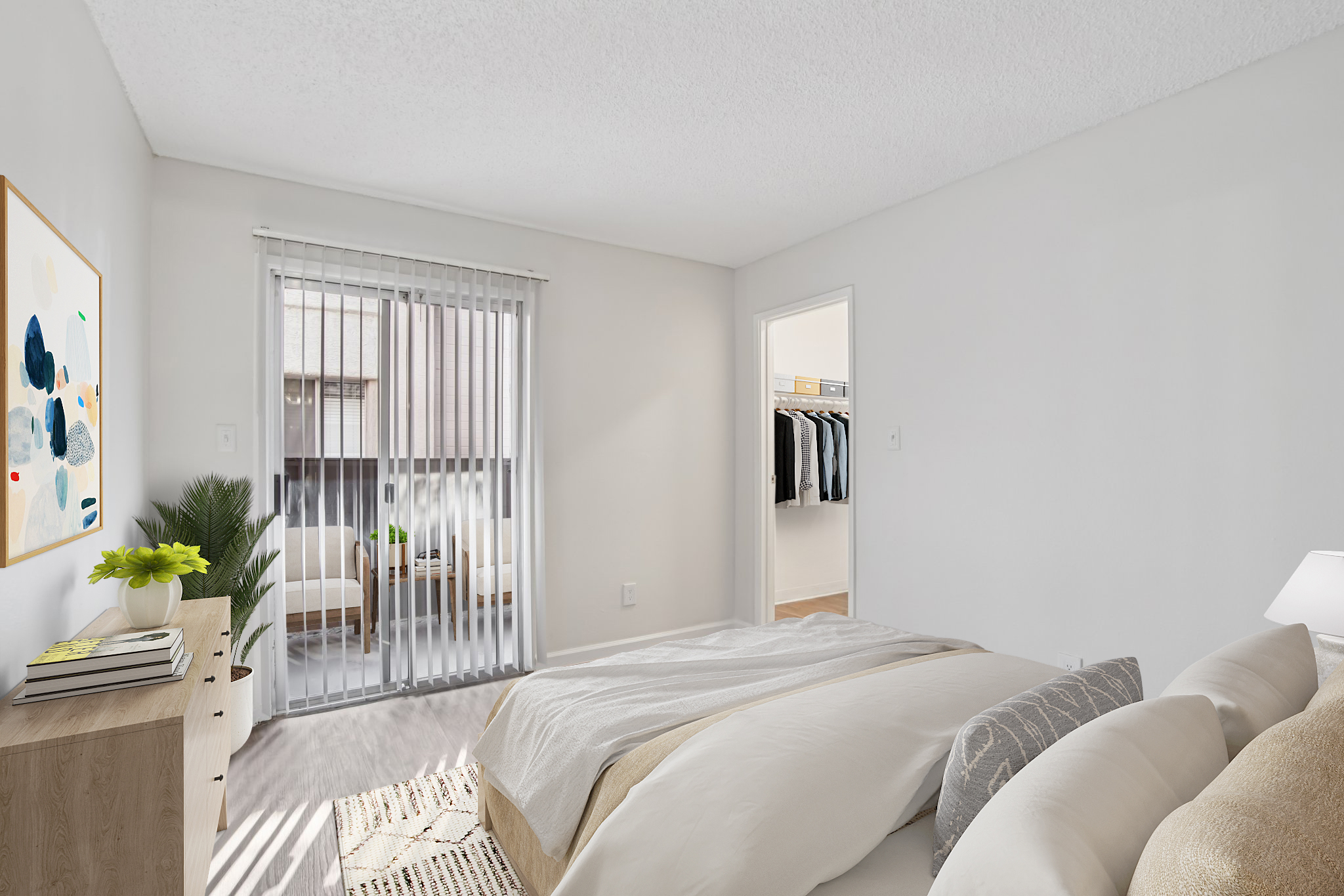 Bright bedroom featuring a queen-sized bed with white bedding, a wooden dresser, and a potted plant. There are sliding glass doors leading to a balcony, alongside a closet visible in the background. The room has light-colored walls and a textured ceiling, creating a cozy and inviting atmosphere.