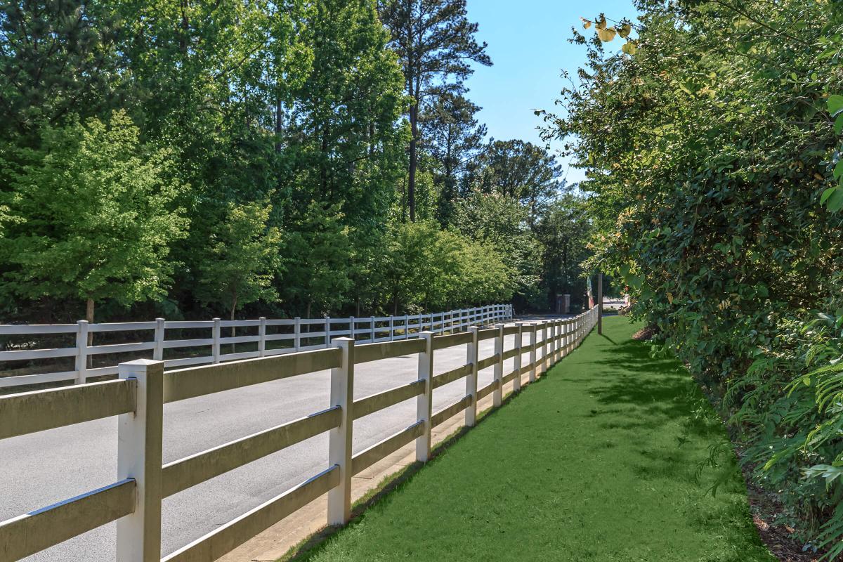 a path with trees on the side of a fence