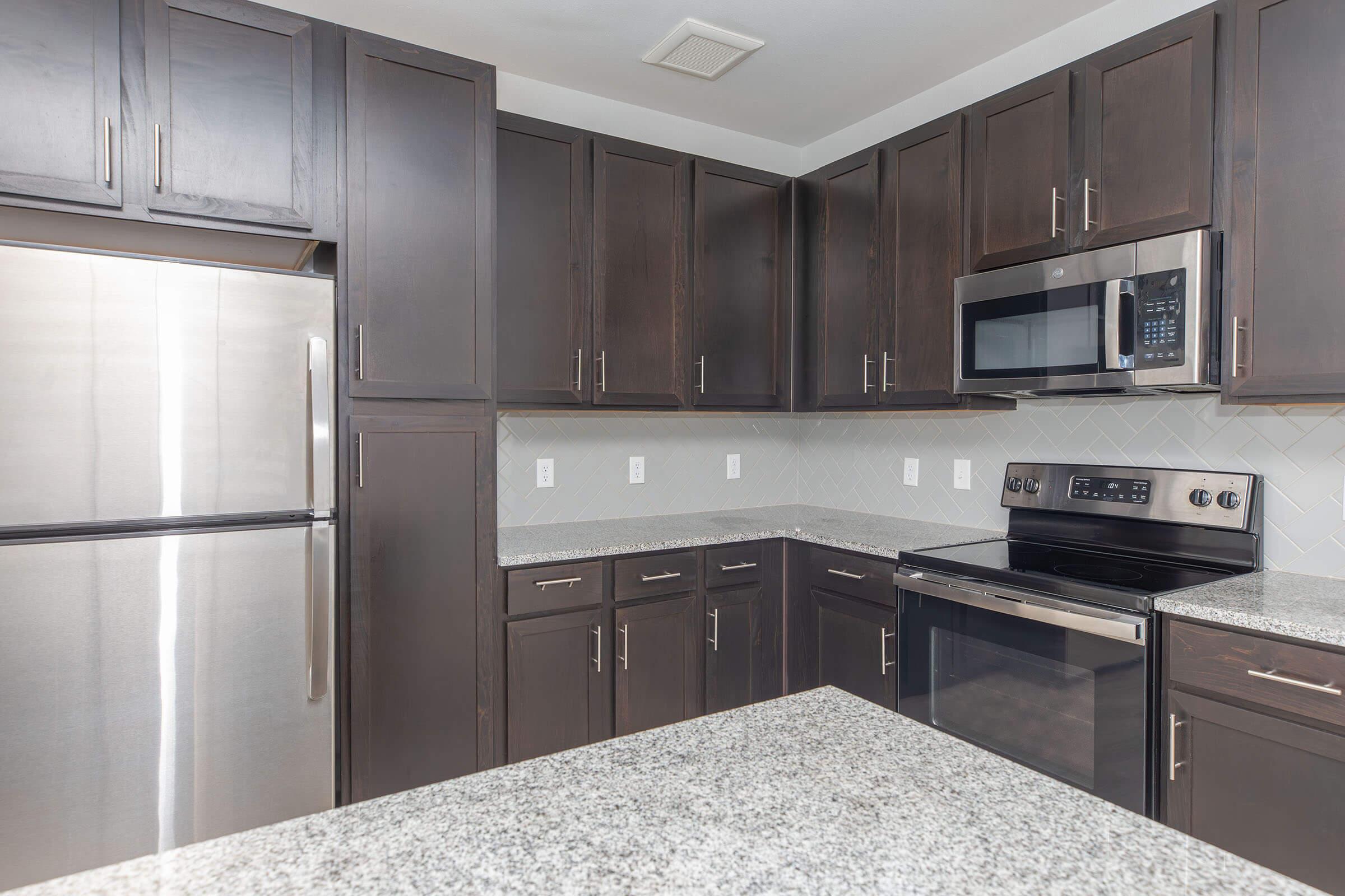 a modern kitchen with stainless steel appliances and wooden cabinets