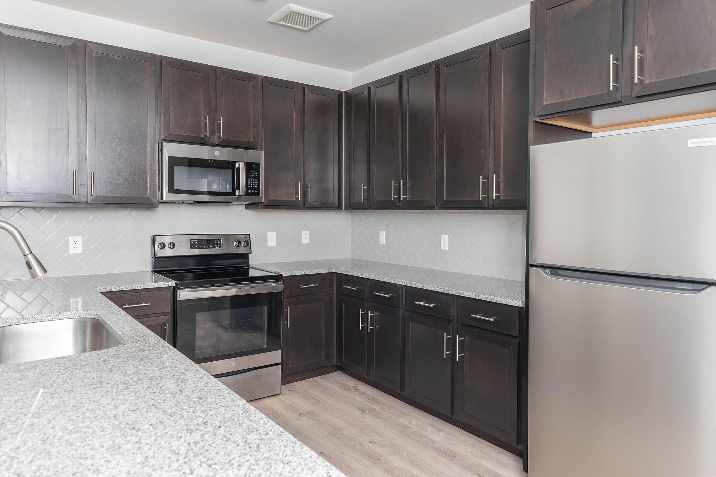 a modern kitchen with stainless steel appliances and wooden cabinets