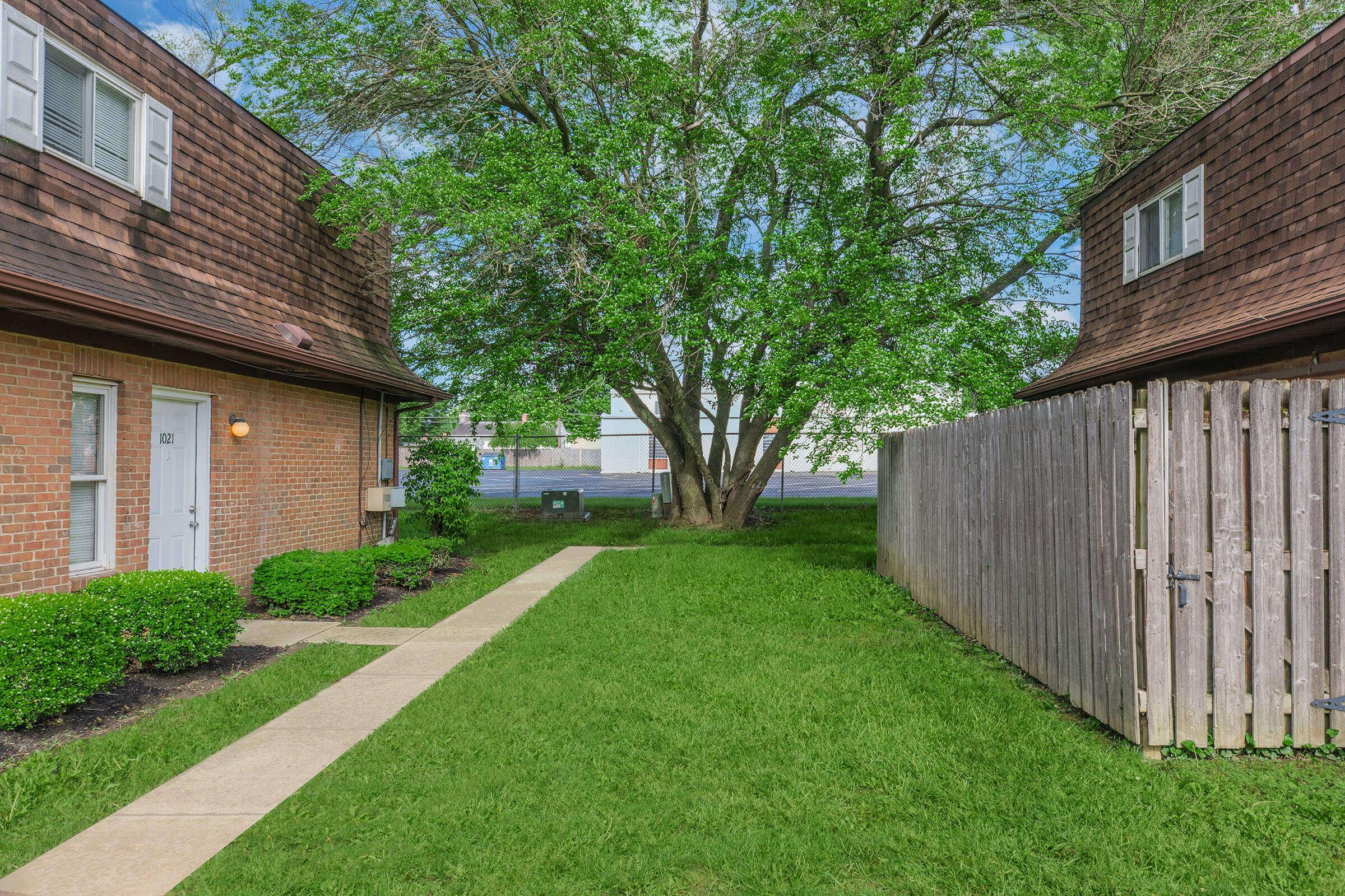 a large brick building with grass in front of a house