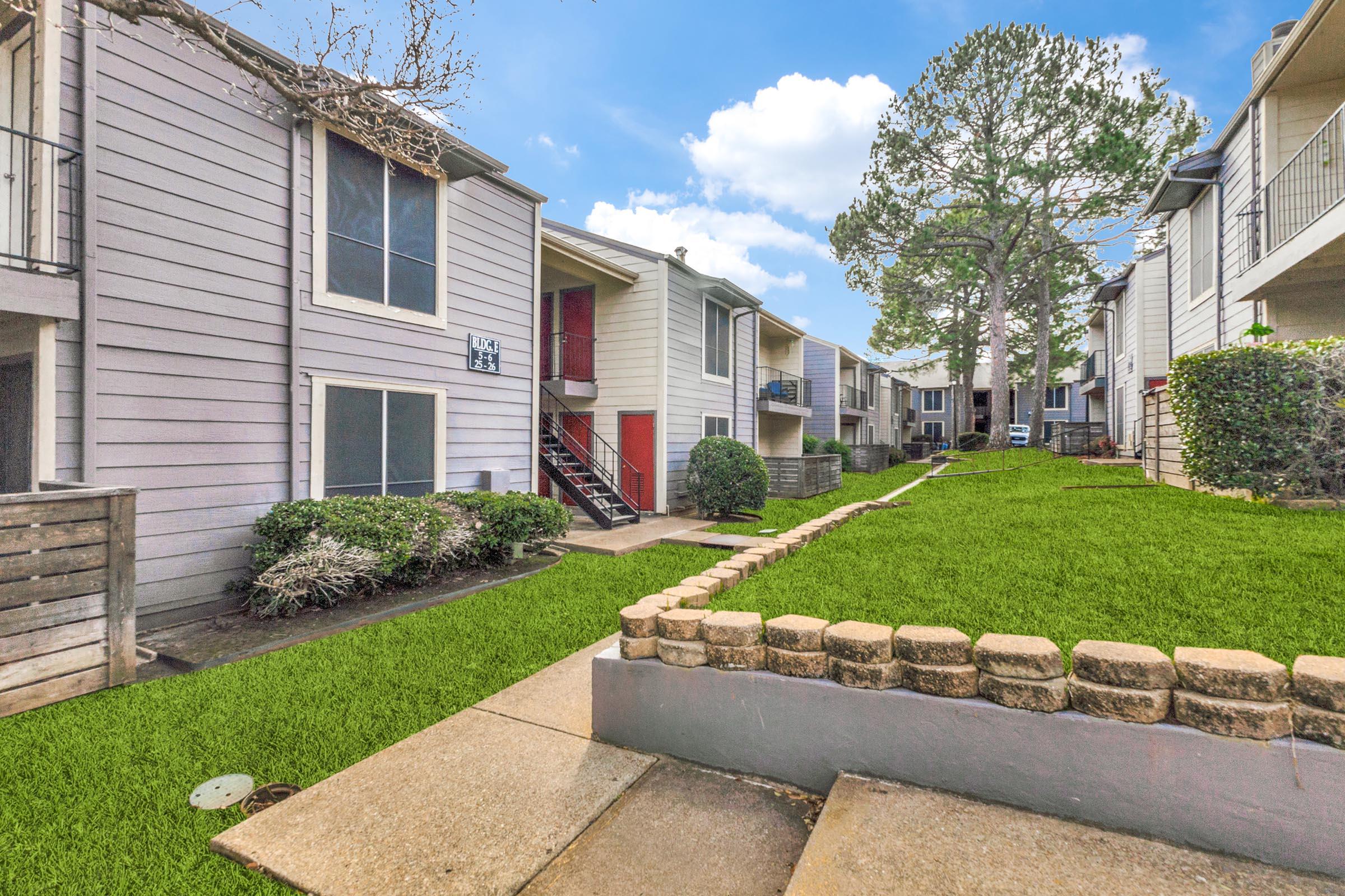 a stone building that has grass in front of a house