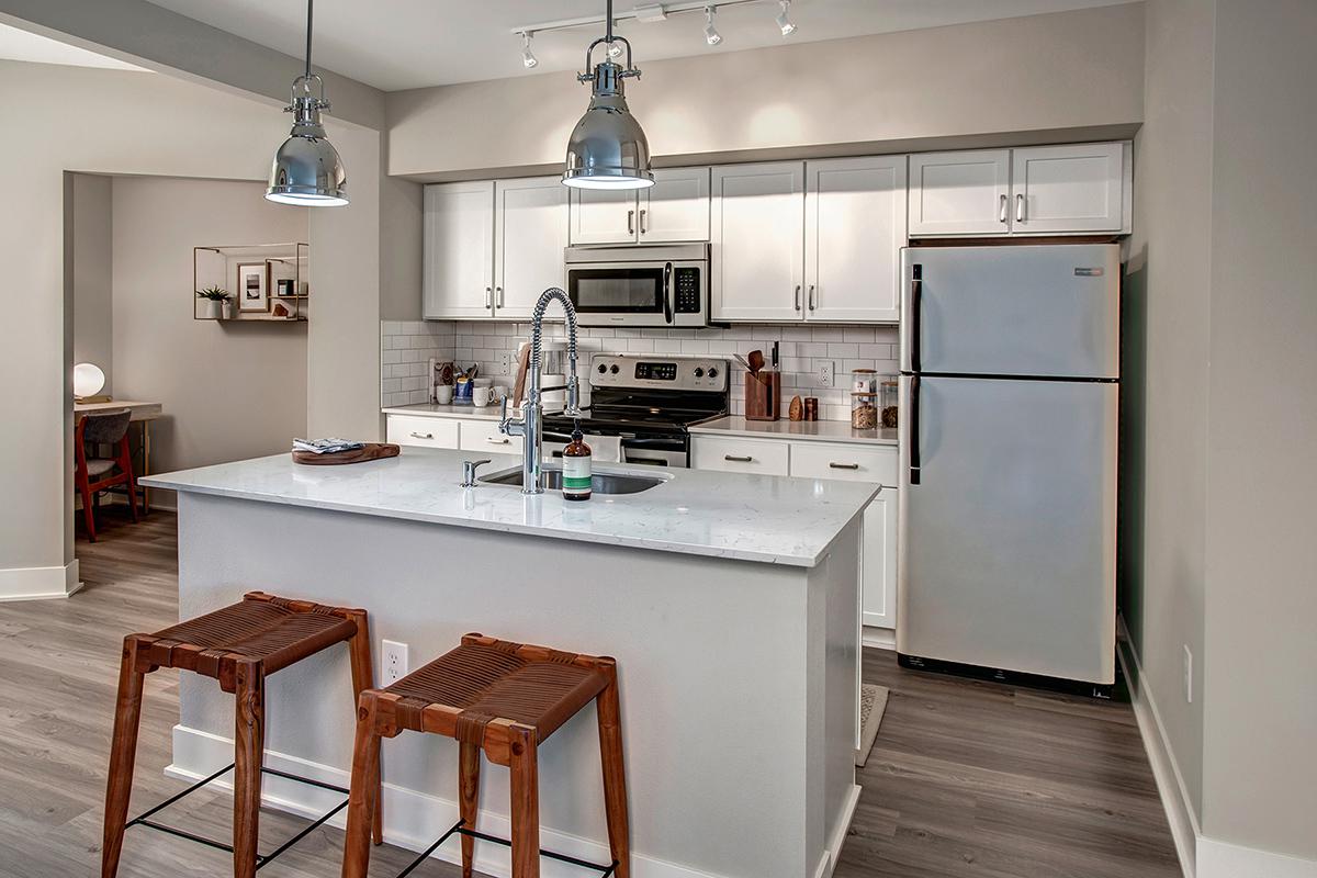 a kitchen with a stove refrigerator and table in a room