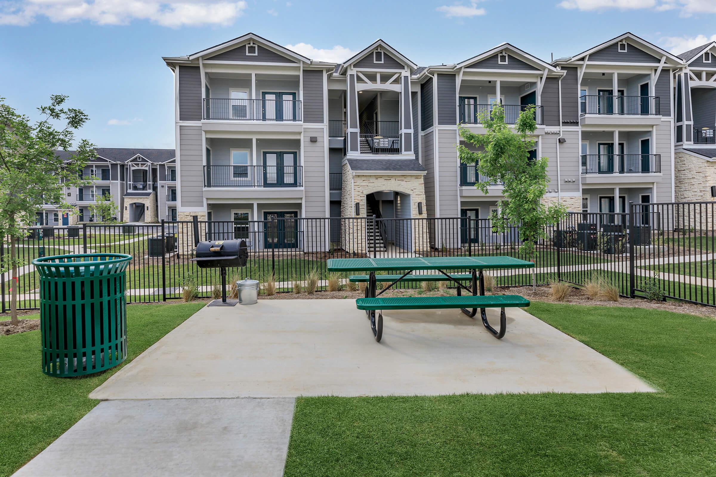 a green park bench sitting in front of a building