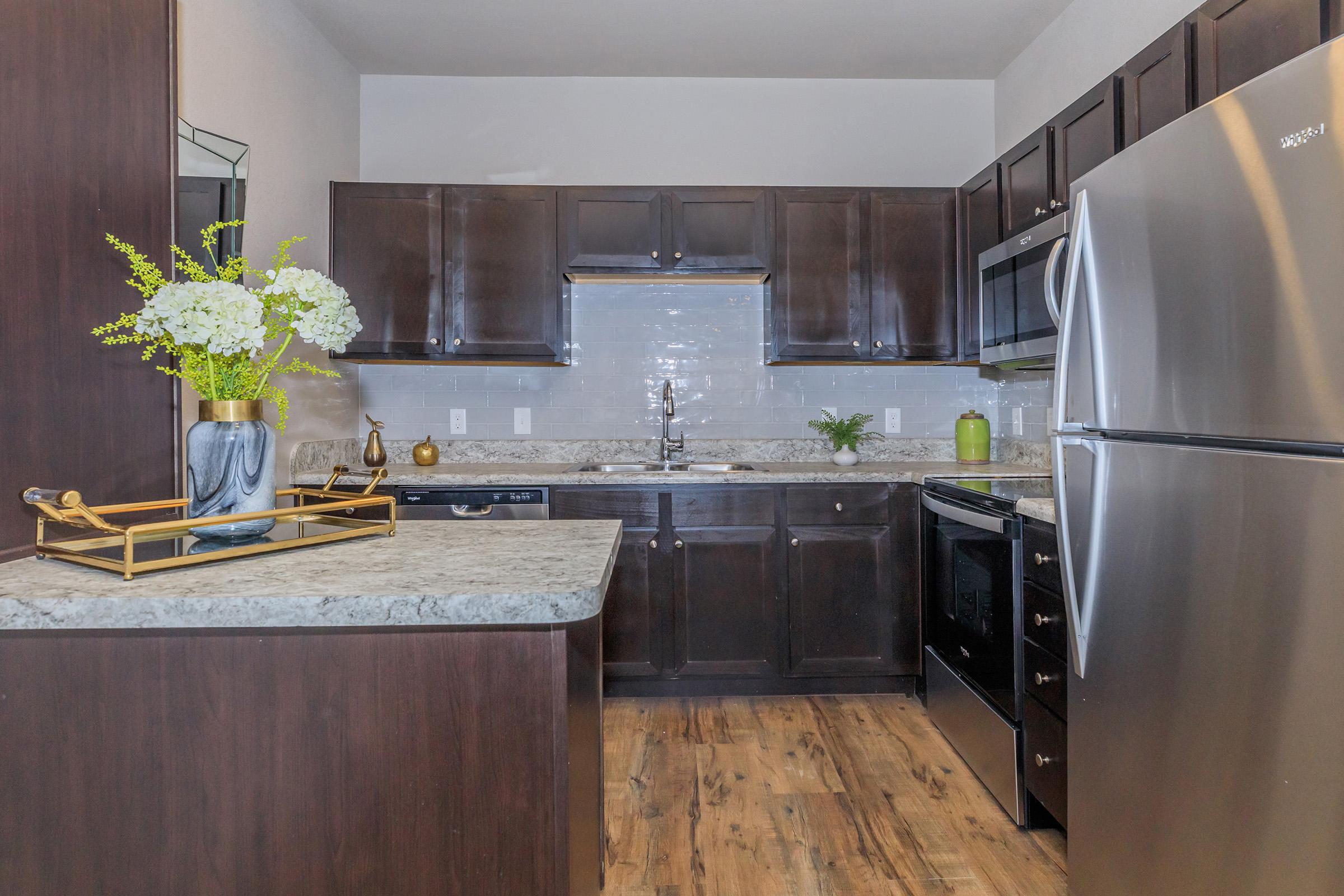 a large kitchen with stainless steel appliances and wooden cabinets