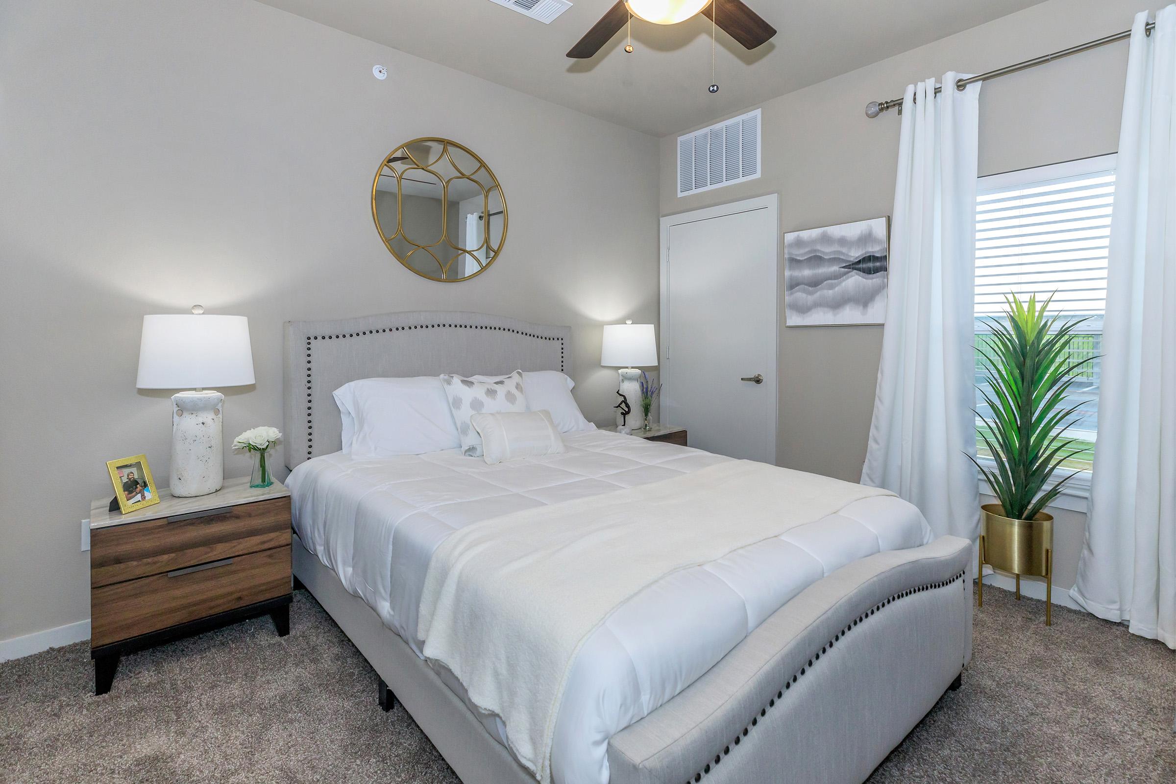 a bedroom with a bed and desk in a hotel room