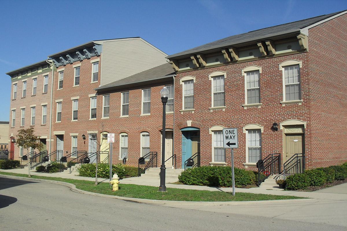 a large brick building with grass in front of a house