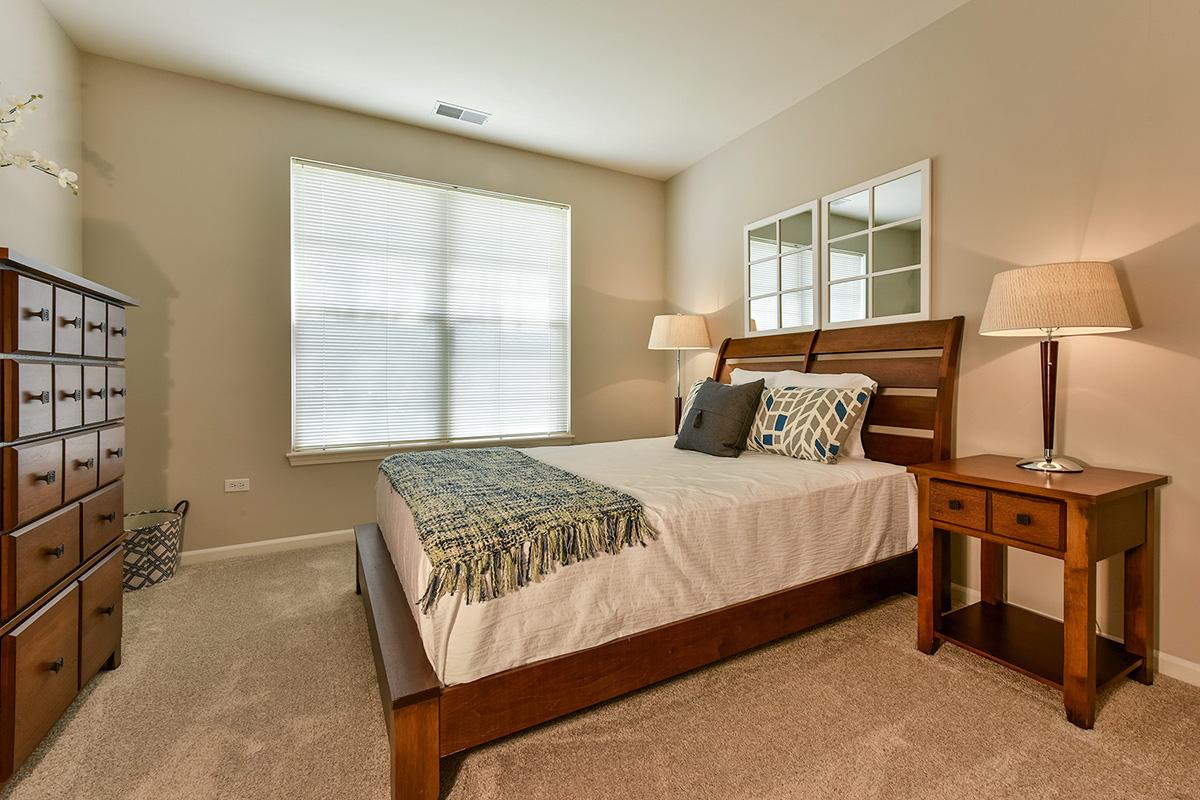 a bedroom with a bed and desk in a hotel room