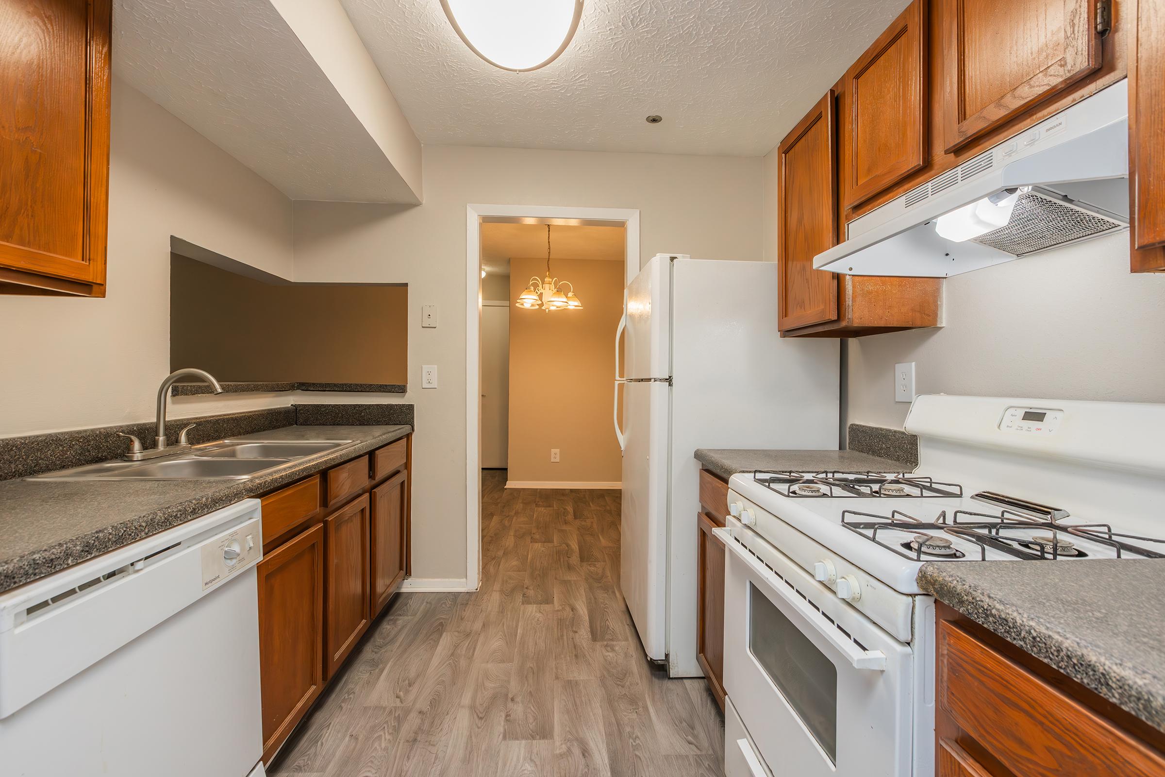 a large kitchen with stainless steel appliances and wooden cabinets