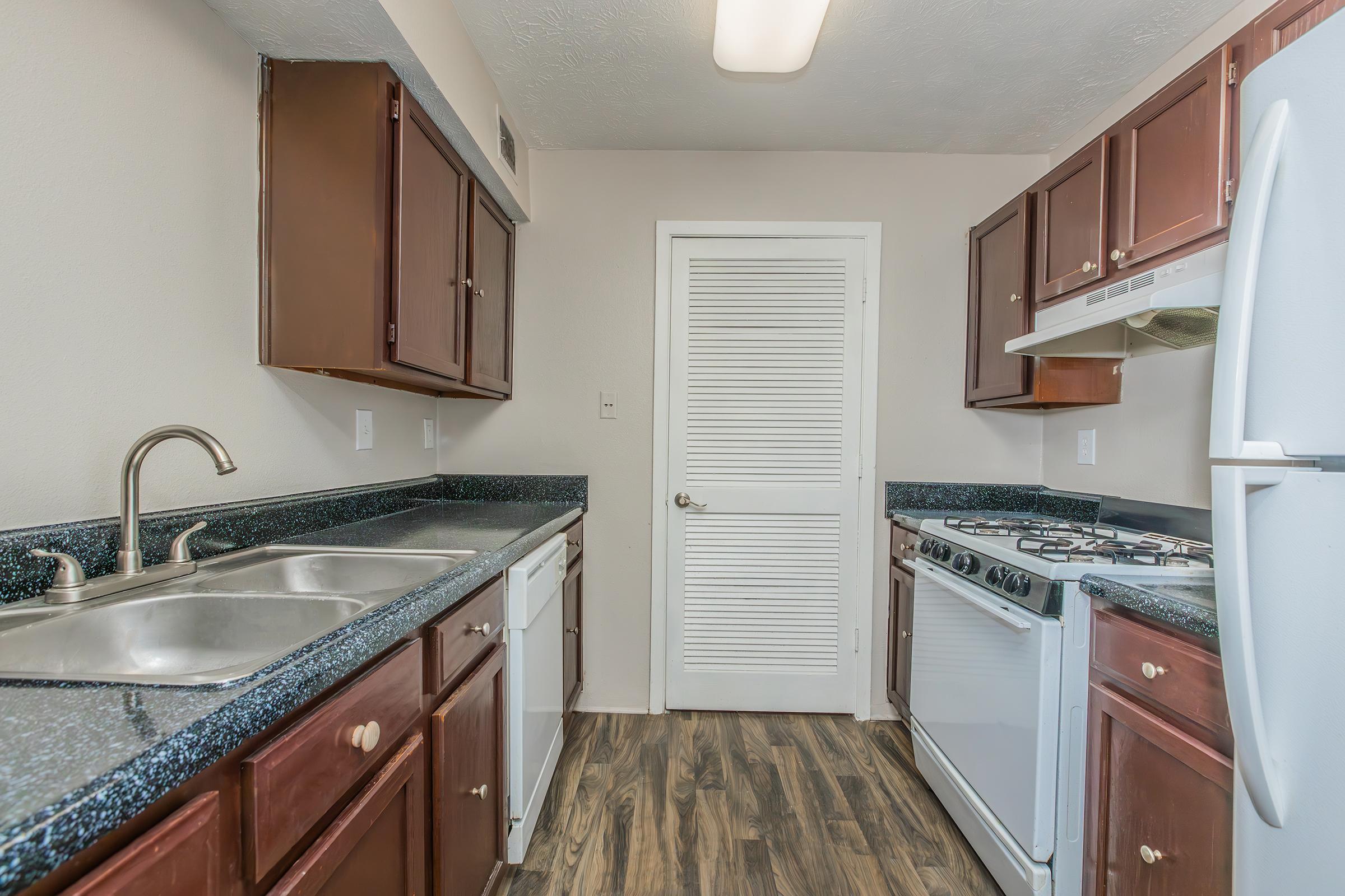 a kitchen with a stove sink and refrigerator