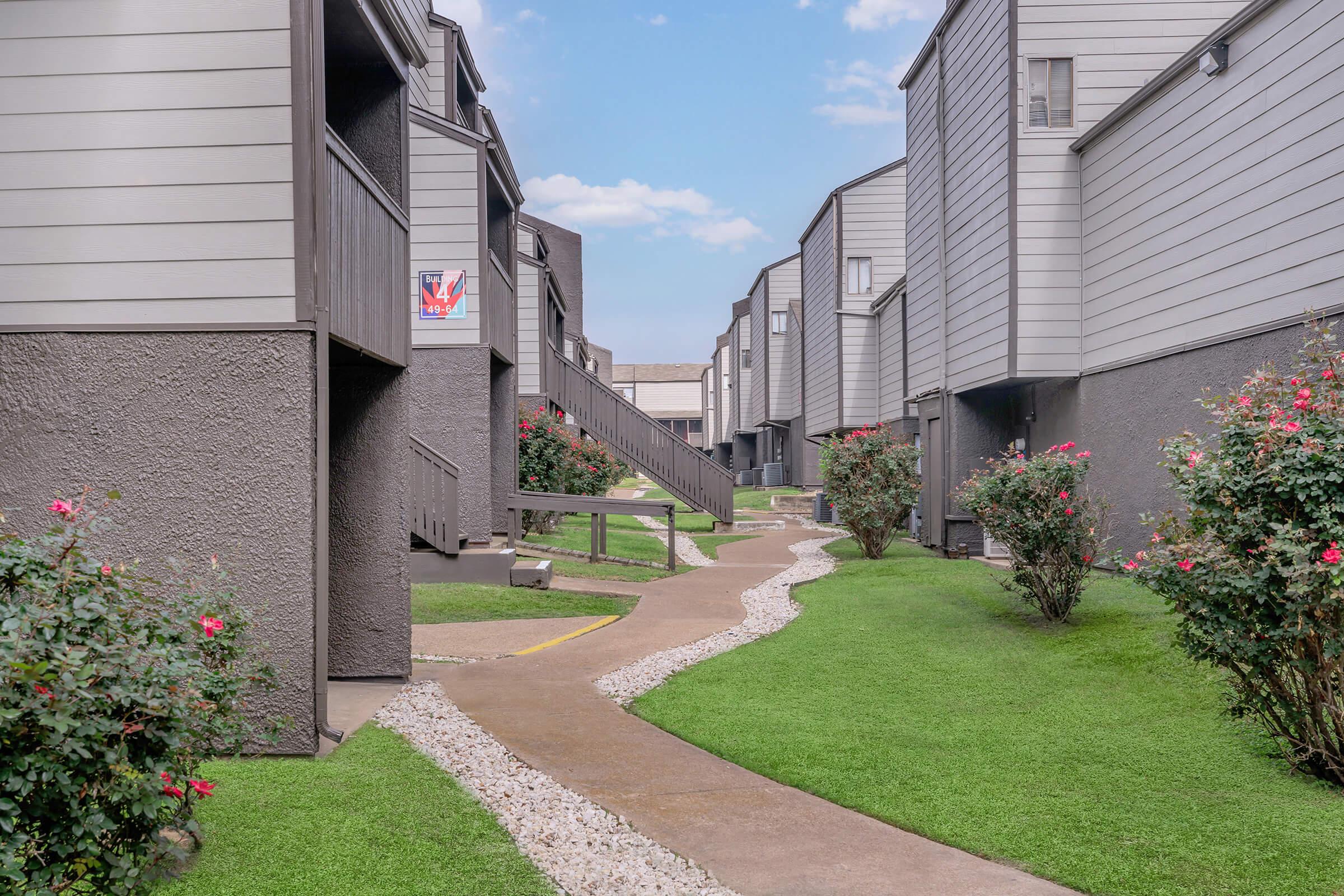 a path with trees on the side of a building