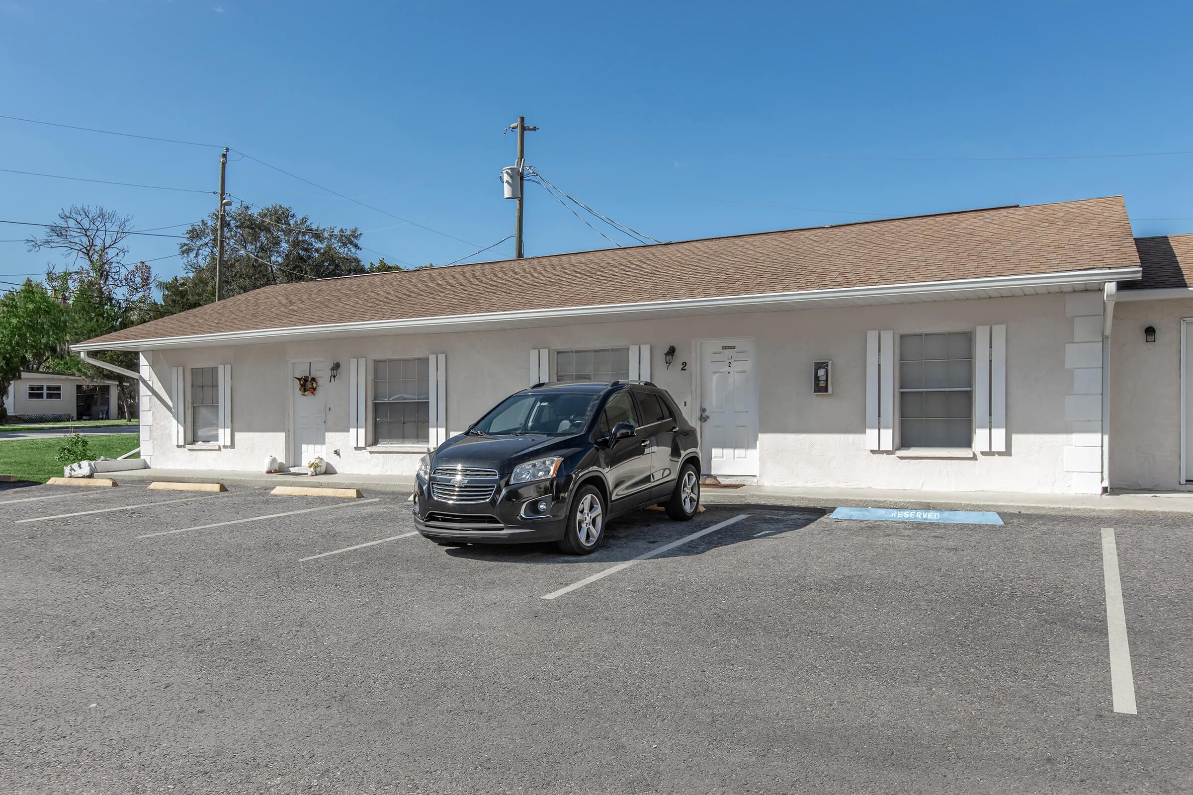 a car parked in a parking lot in front of a house