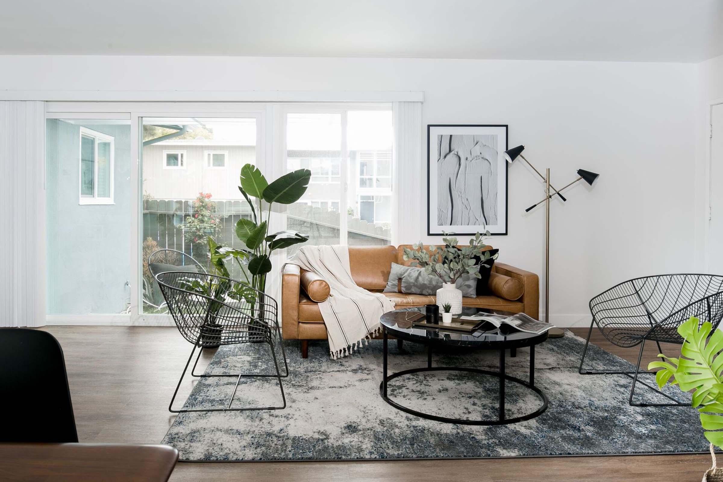 Living room with a leather sofa against a bright backdrop and sliding glass doors