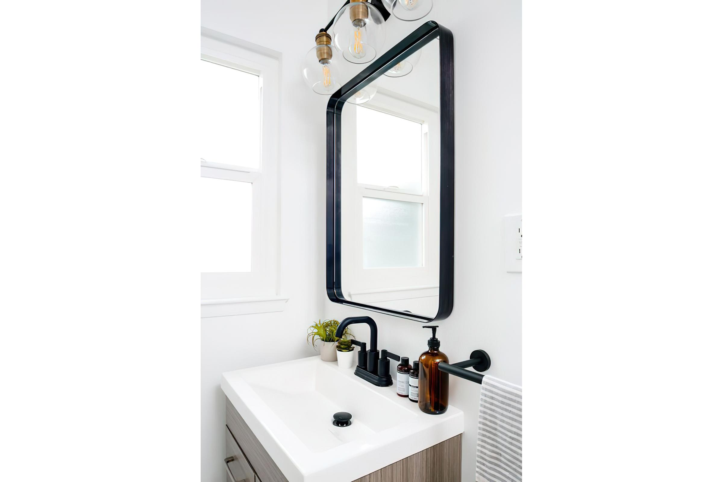 Stylish mirror with black finish fixtures and sink