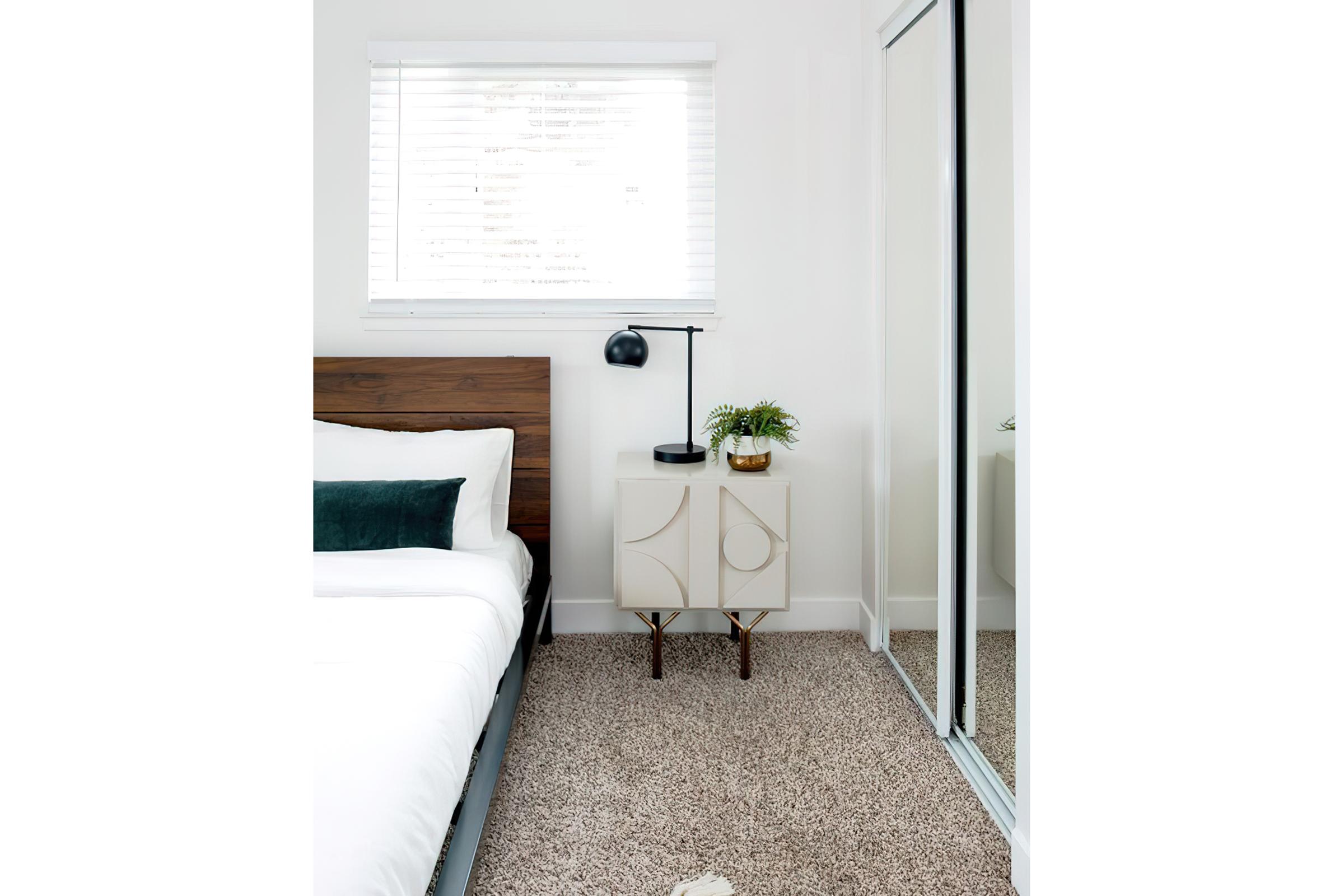 Master Bedroom with mirrored sliding closet doors and another window with blinds