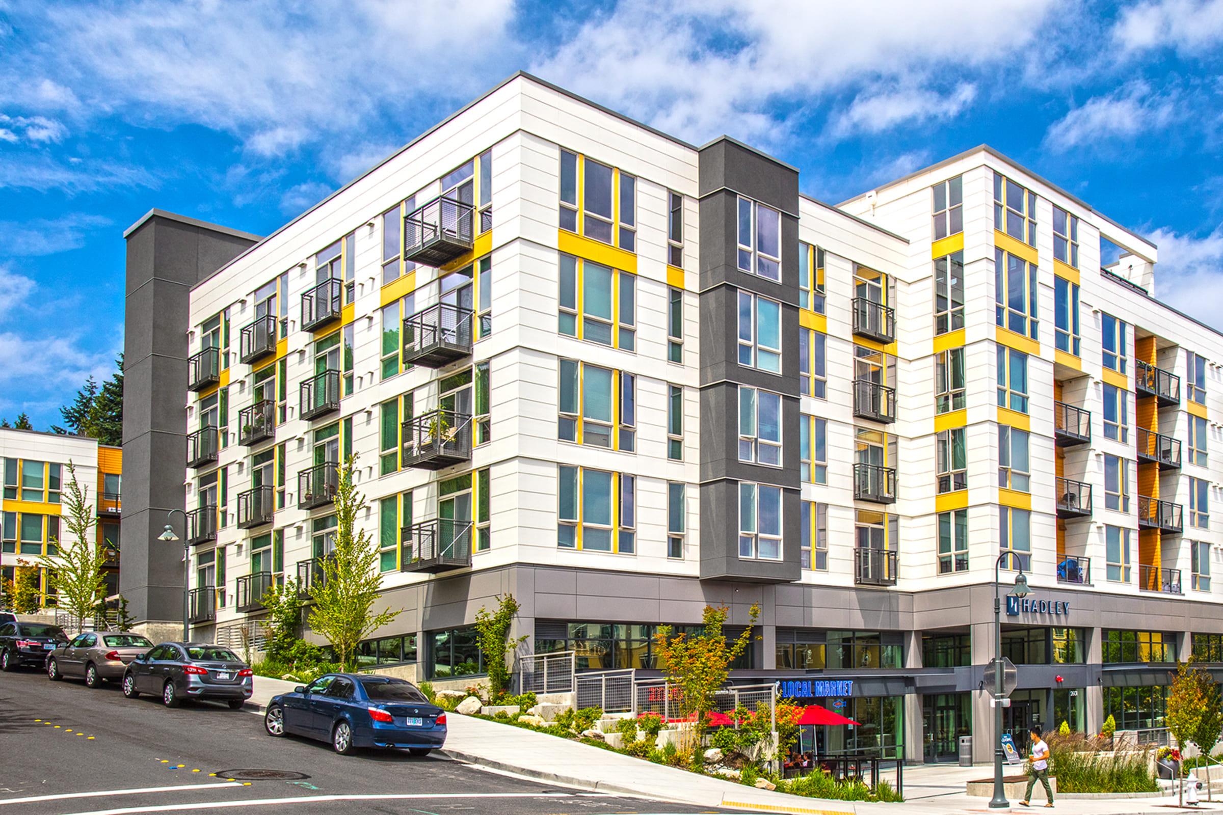 Modern apartment building with multiple floors, large windows, and balconies.