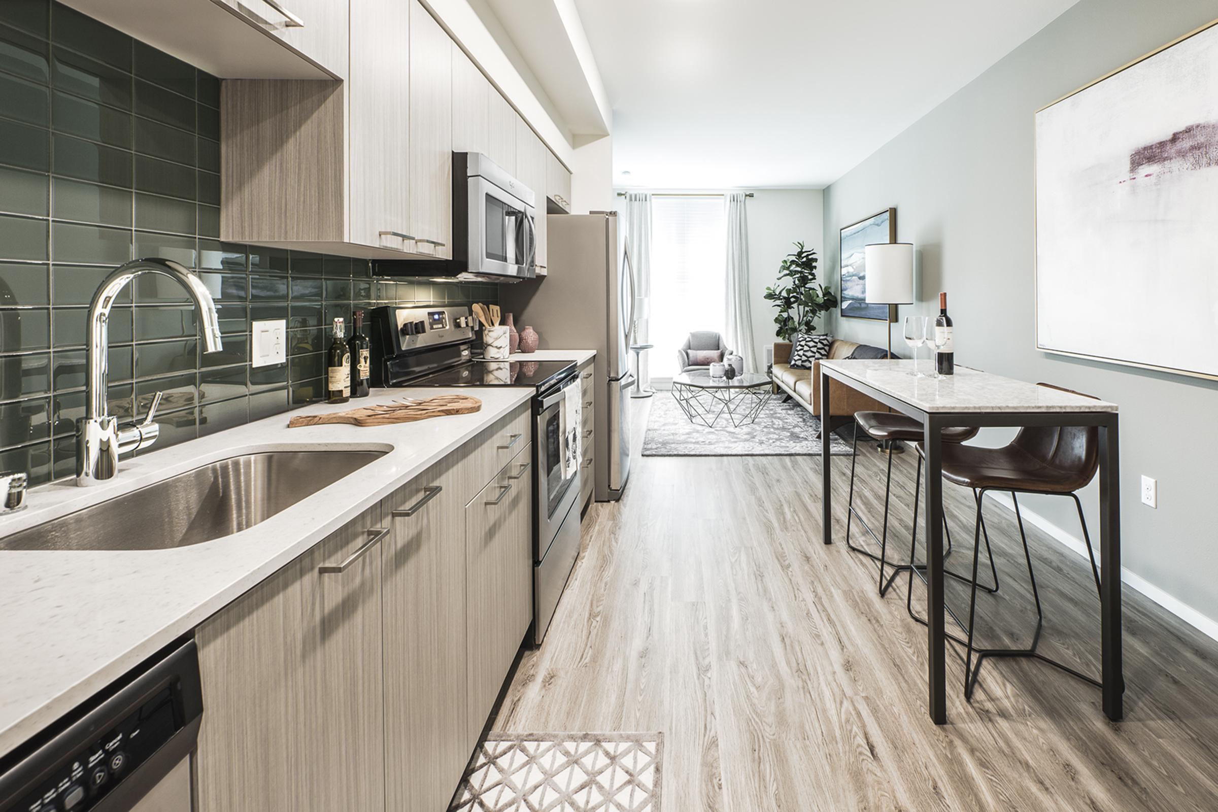 Modern kitchen featuring a stainless steel refrigerator, microwave, and oven.