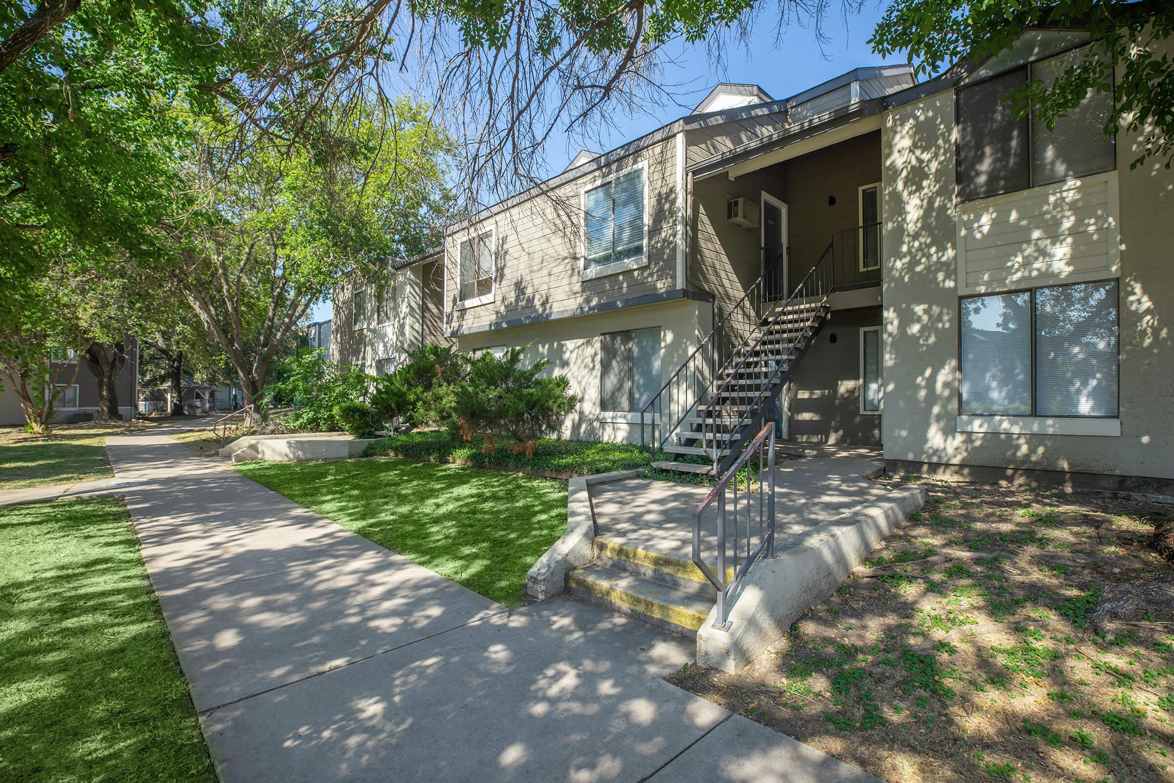 a path with trees on the side of a building