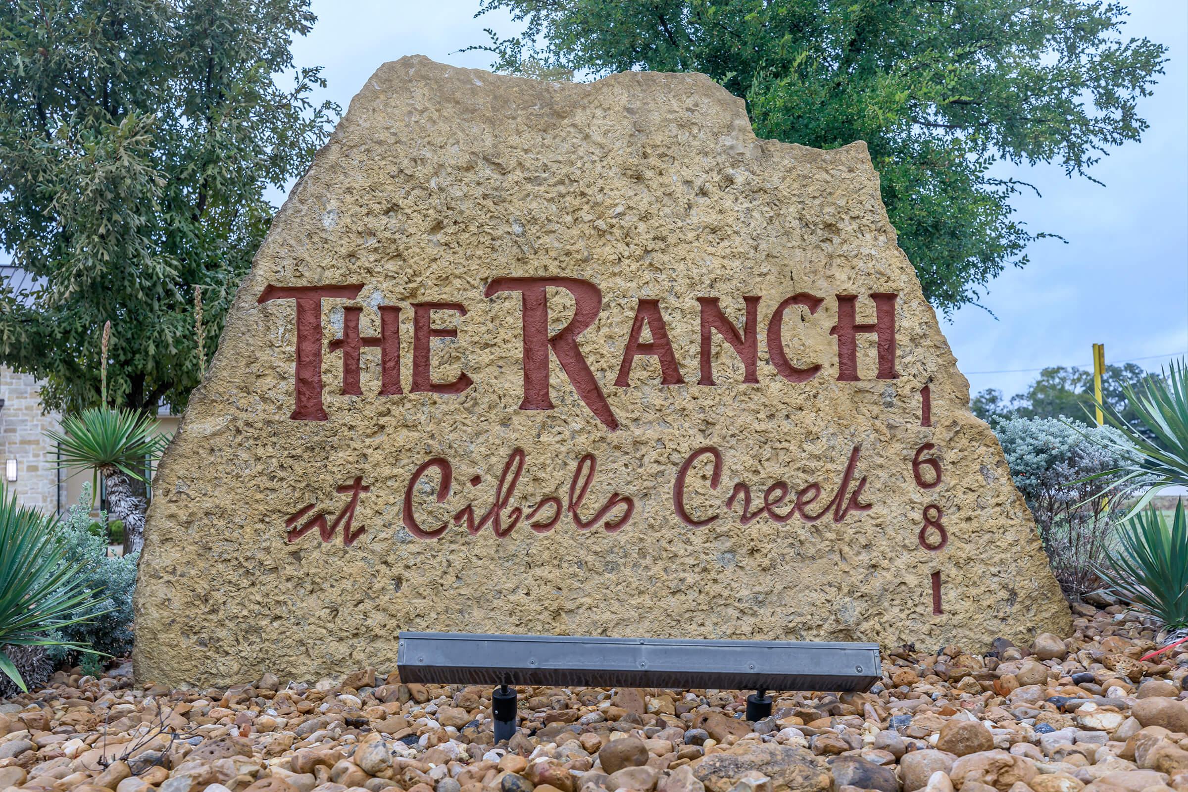a sign in front of a large rock
