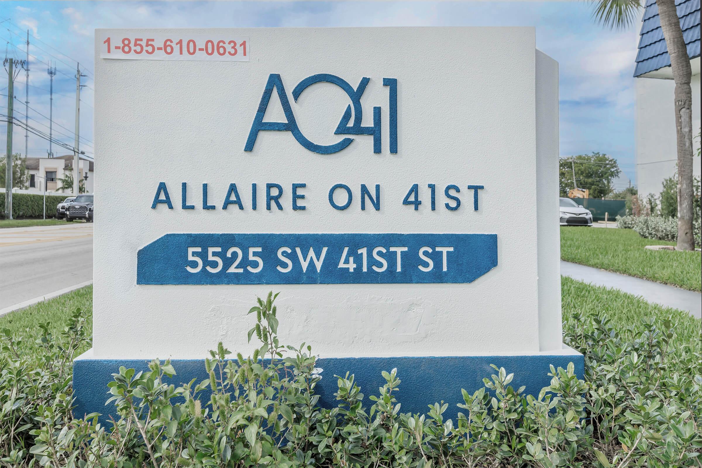 Sign for Allaire on 41st, featuring the address "5525 SW 41ST ST" and a phone number "1-855-610-0631." The sign has a modern design with blue and white colors, surrounded by green landscaping.