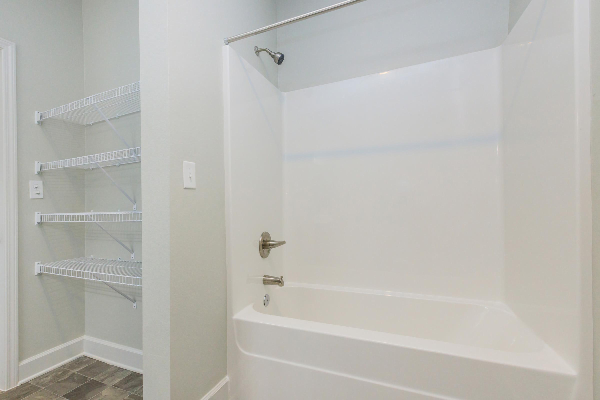 a room with a sink and a white tub sitting next to a shower