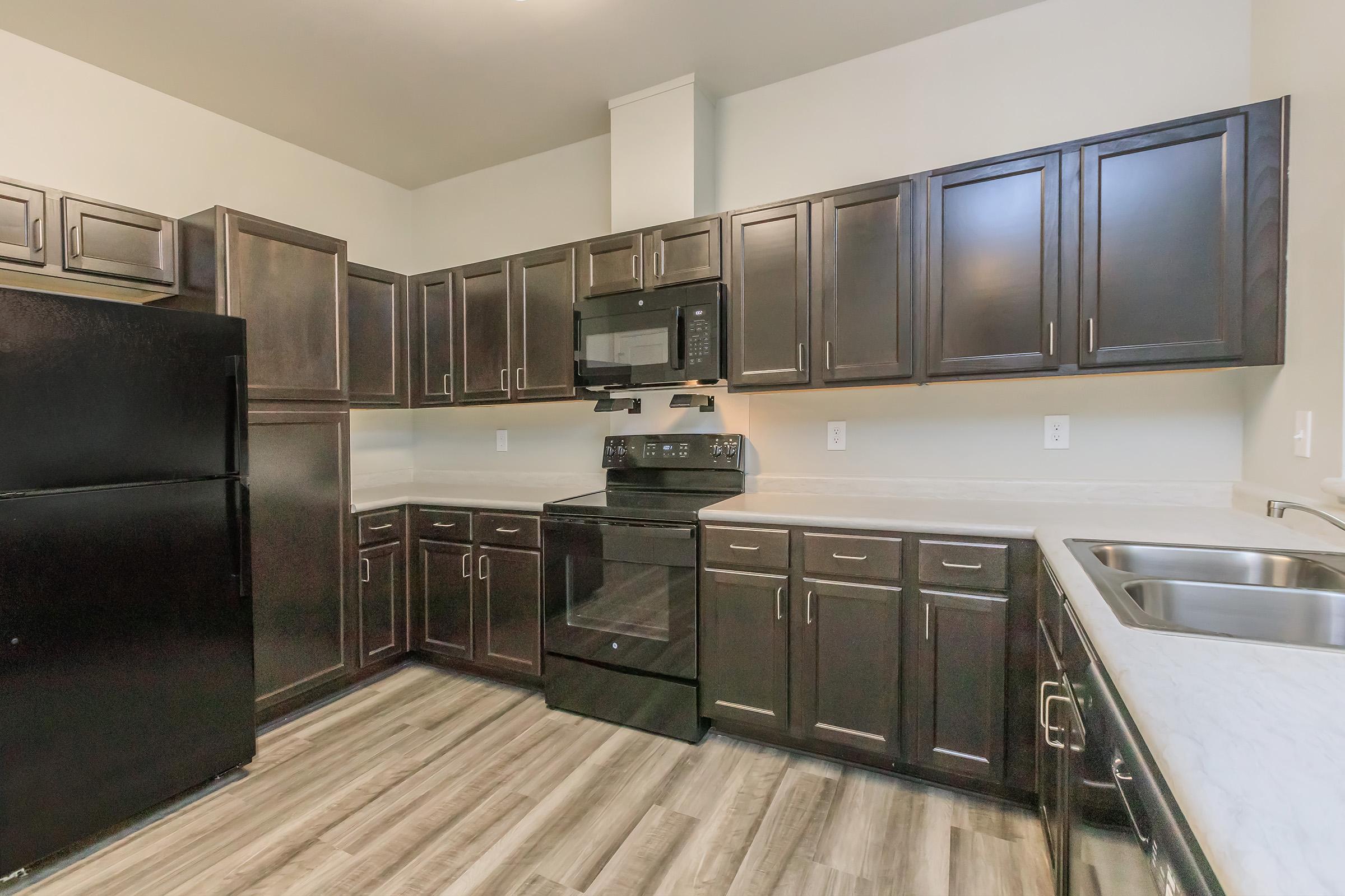 a large kitchen with stainless steel appliances and wooden cabinets