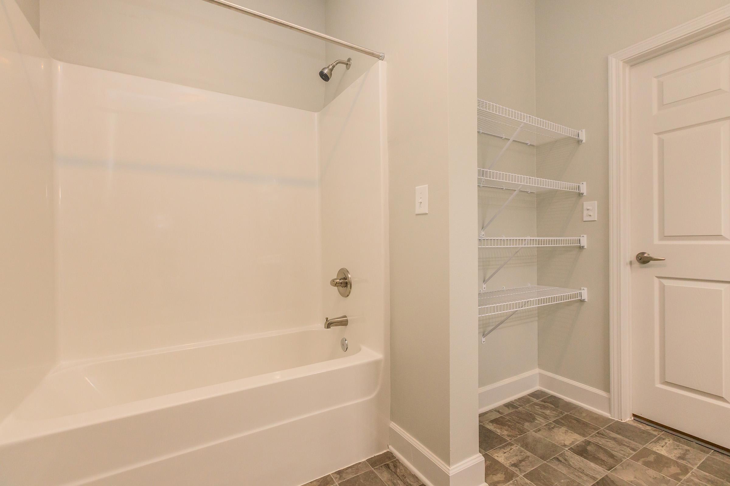 a room with a sink and a white tub sitting next to a shower