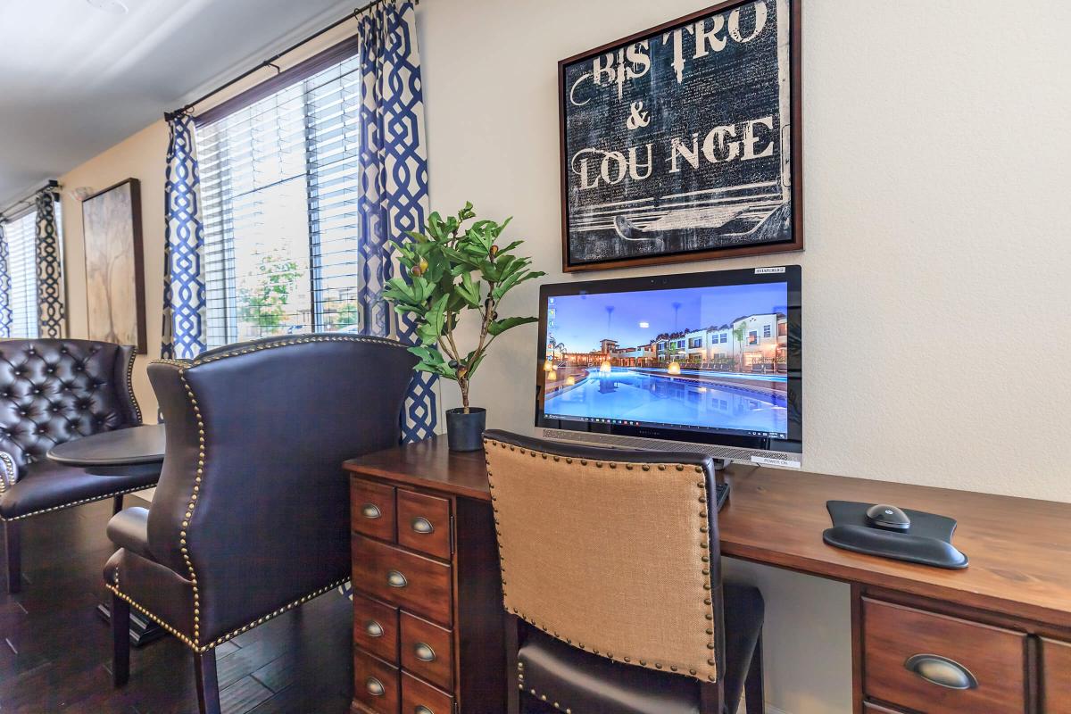 a desk with a computer and a chair in a room