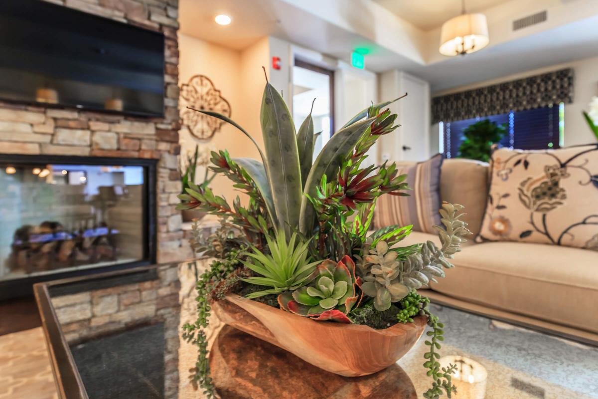 a living room filled with furniture and vase of flowers on a table