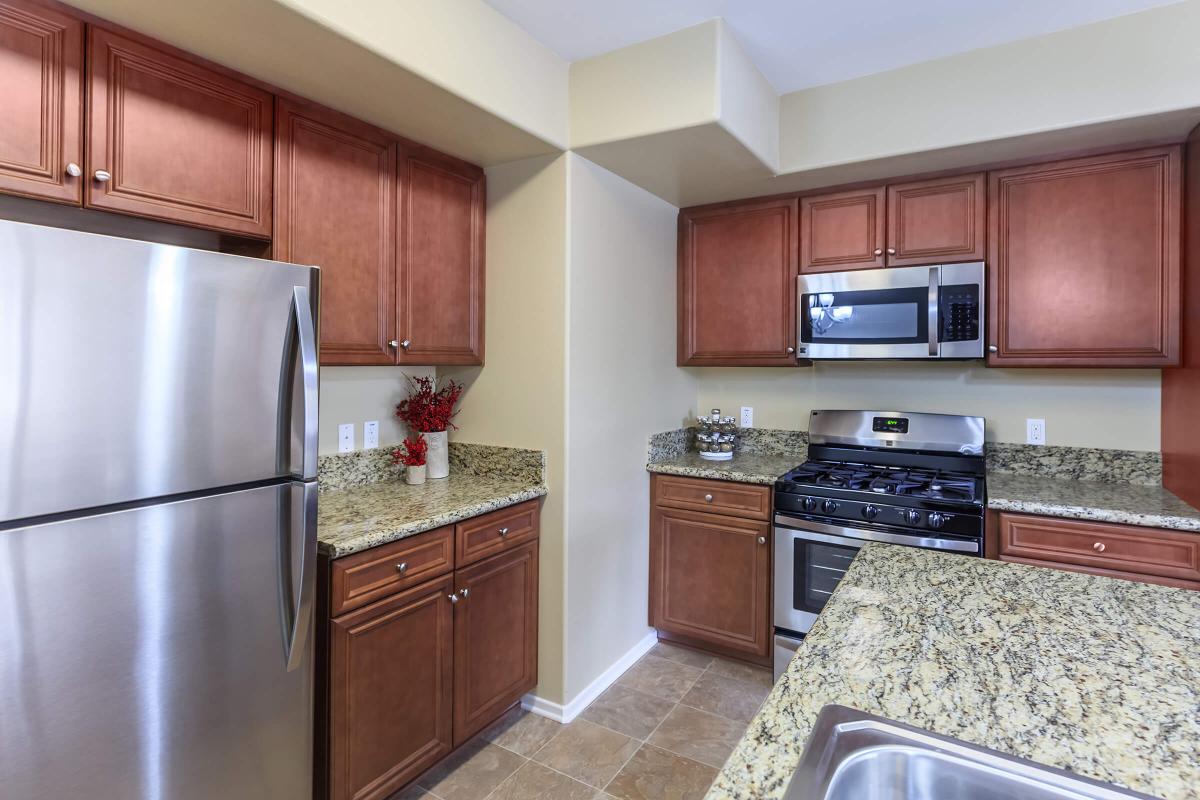 a modern kitchen with stainless steel appliances and wooden cabinets