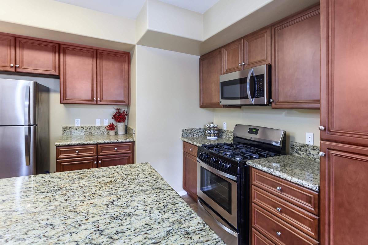 a modern kitchen with stainless steel appliances and wooden cabinets