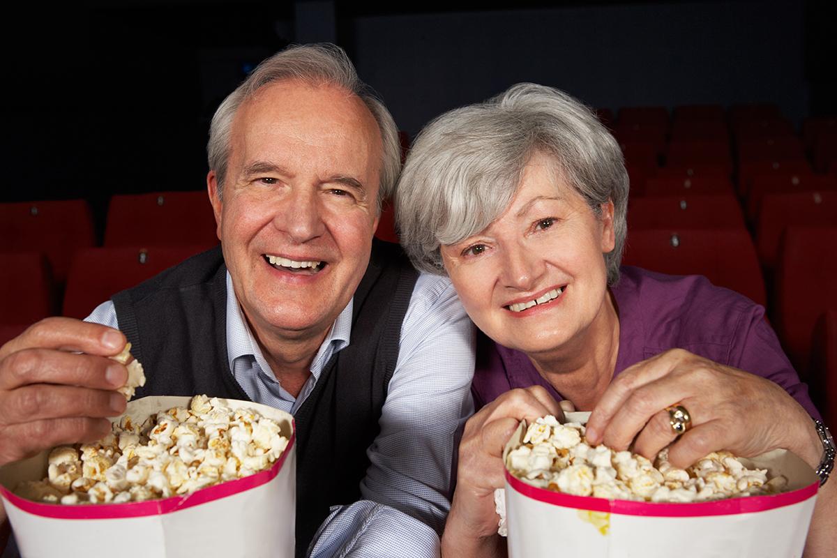 a man and a woman sitting at a table with a plate of food