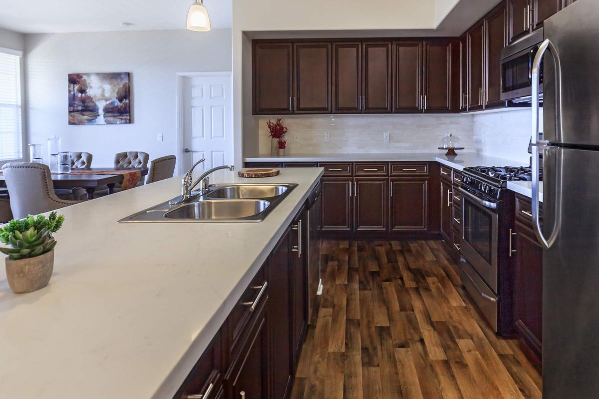 a large kitchen with stainless steel appliances and wooden cabinets