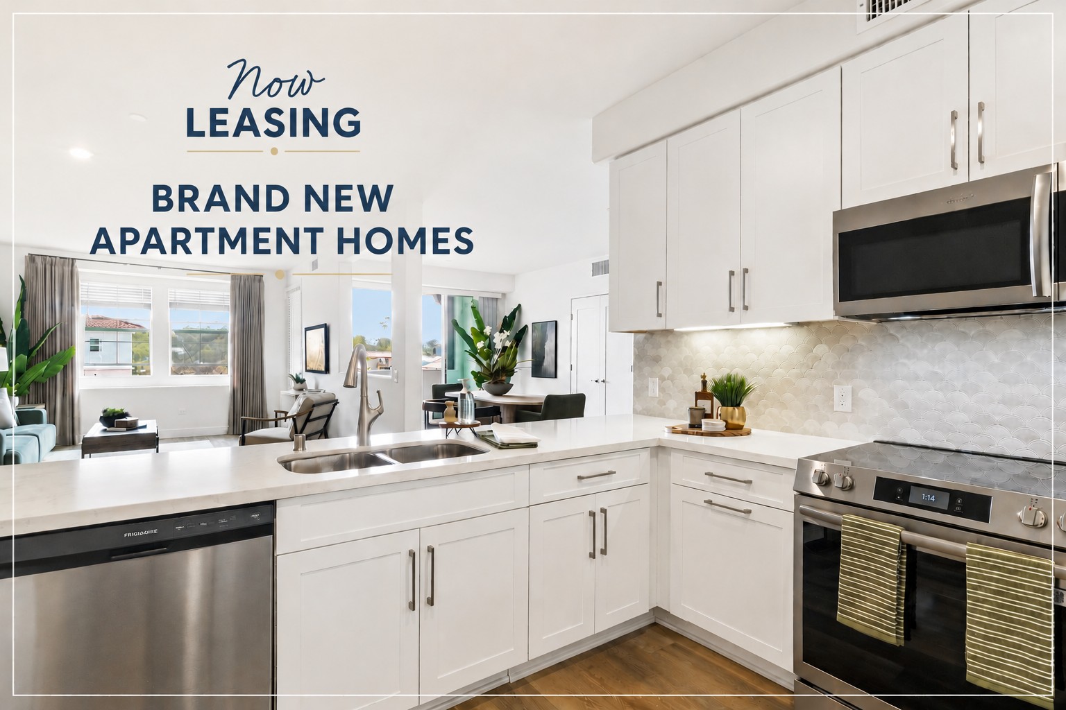Bright and modern kitchen featuring stainless steel appliances, white cabinetry, and a spacious countertop. A dining area is visible in the background, complemented by large windows that provide natural light and a view of the outdoors. Text overlay announces "Now Leasing Brand New Apartment Homes."