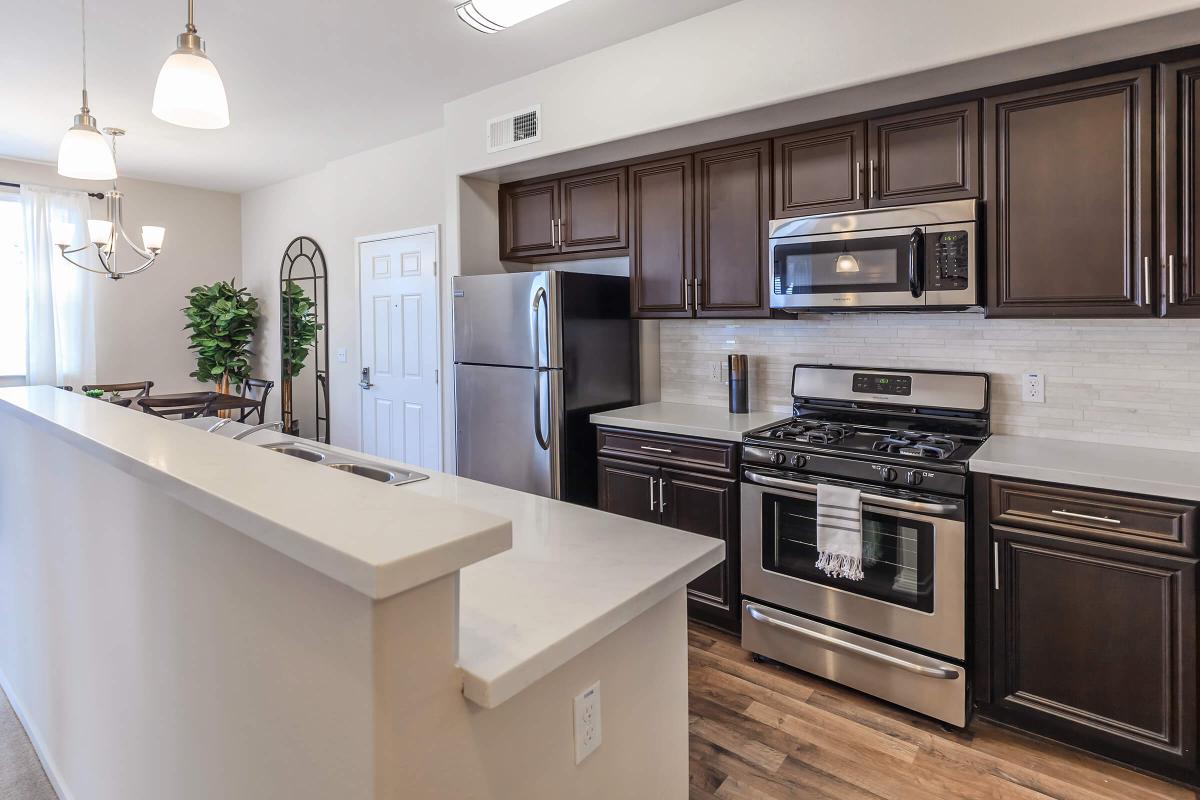 a modern kitchen with stainless steel appliances and wooden cabinets